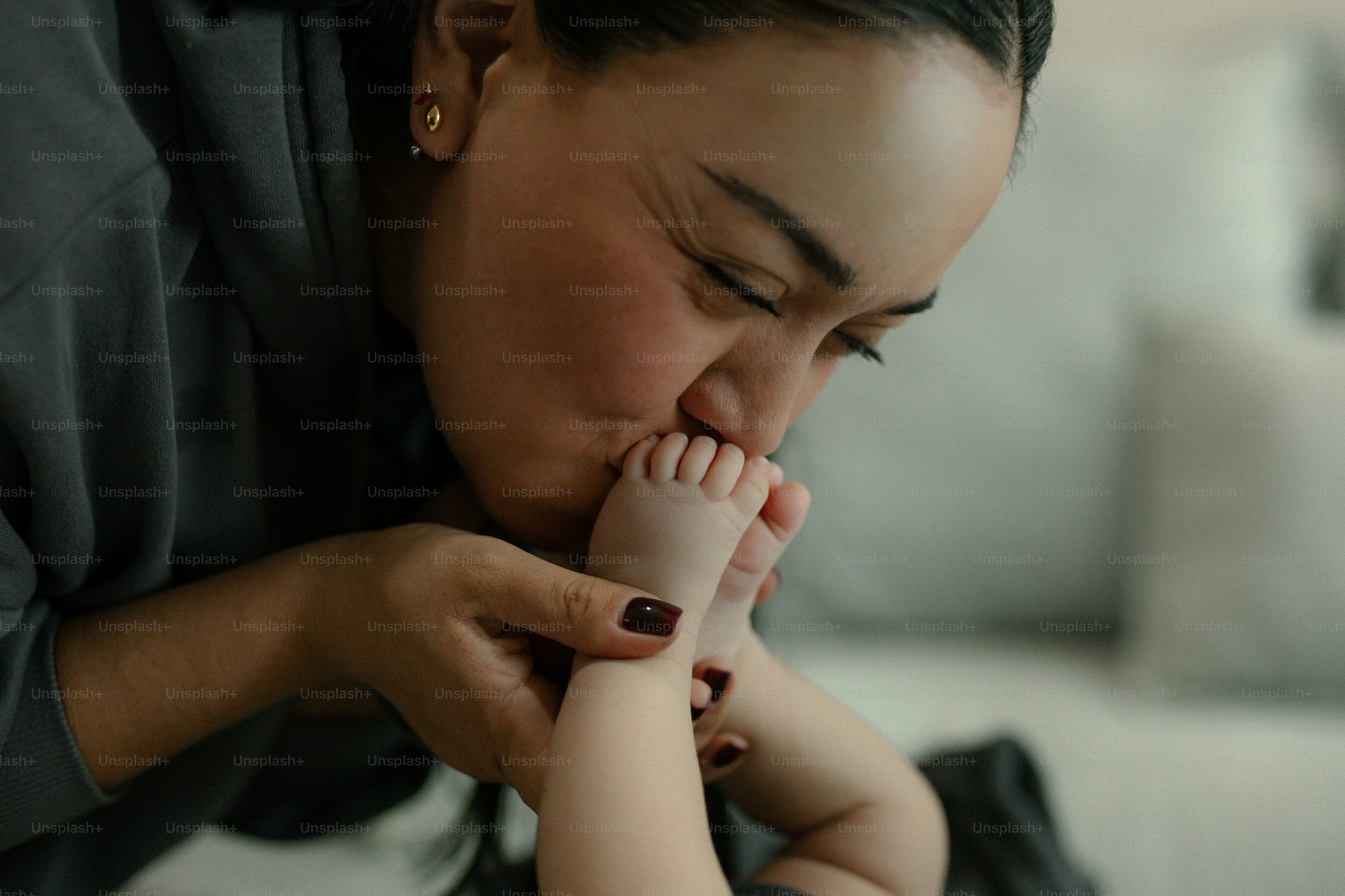 Mãe beijando os pés minúsculos do bebê