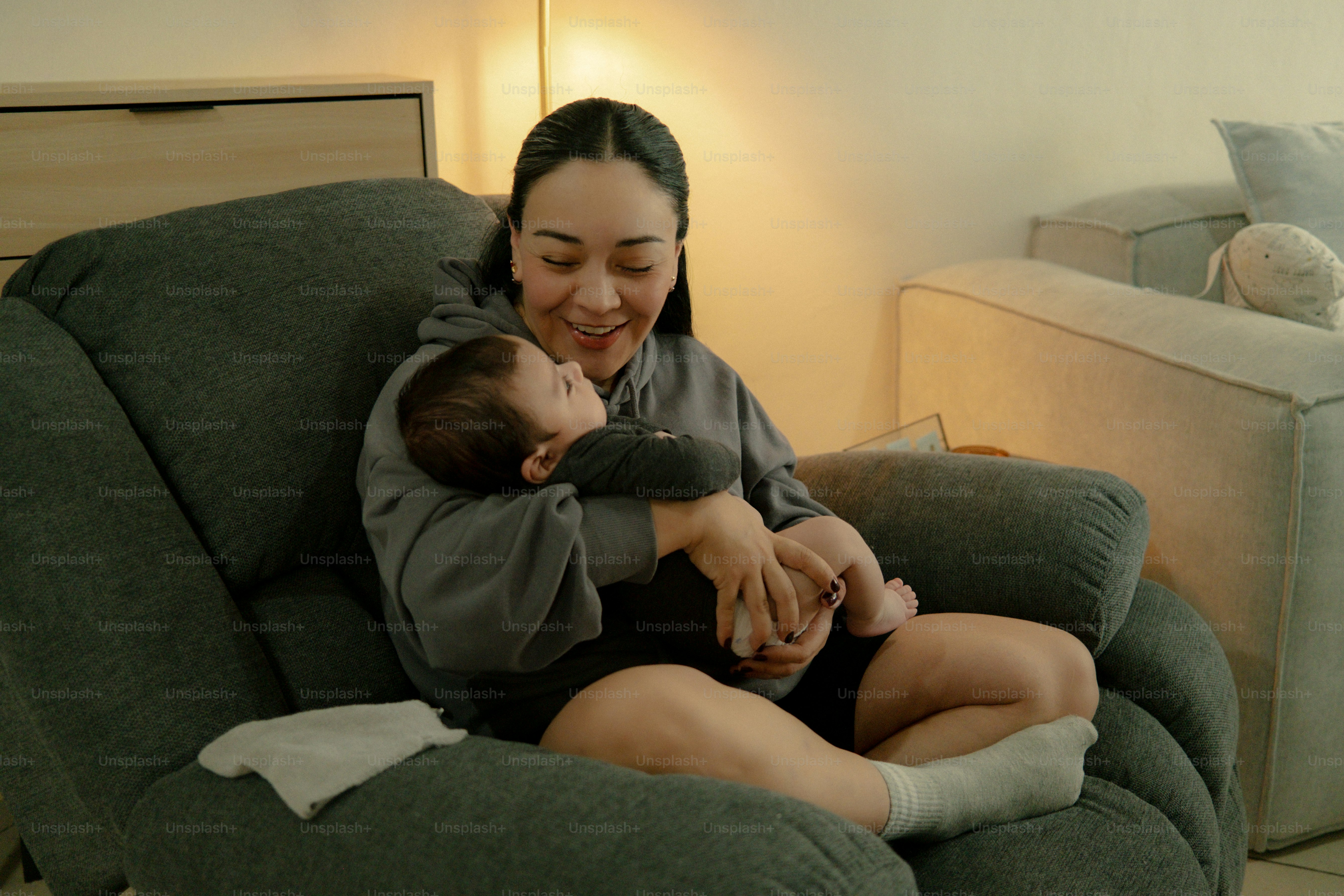Mother holding her baby in a comfortable chair.