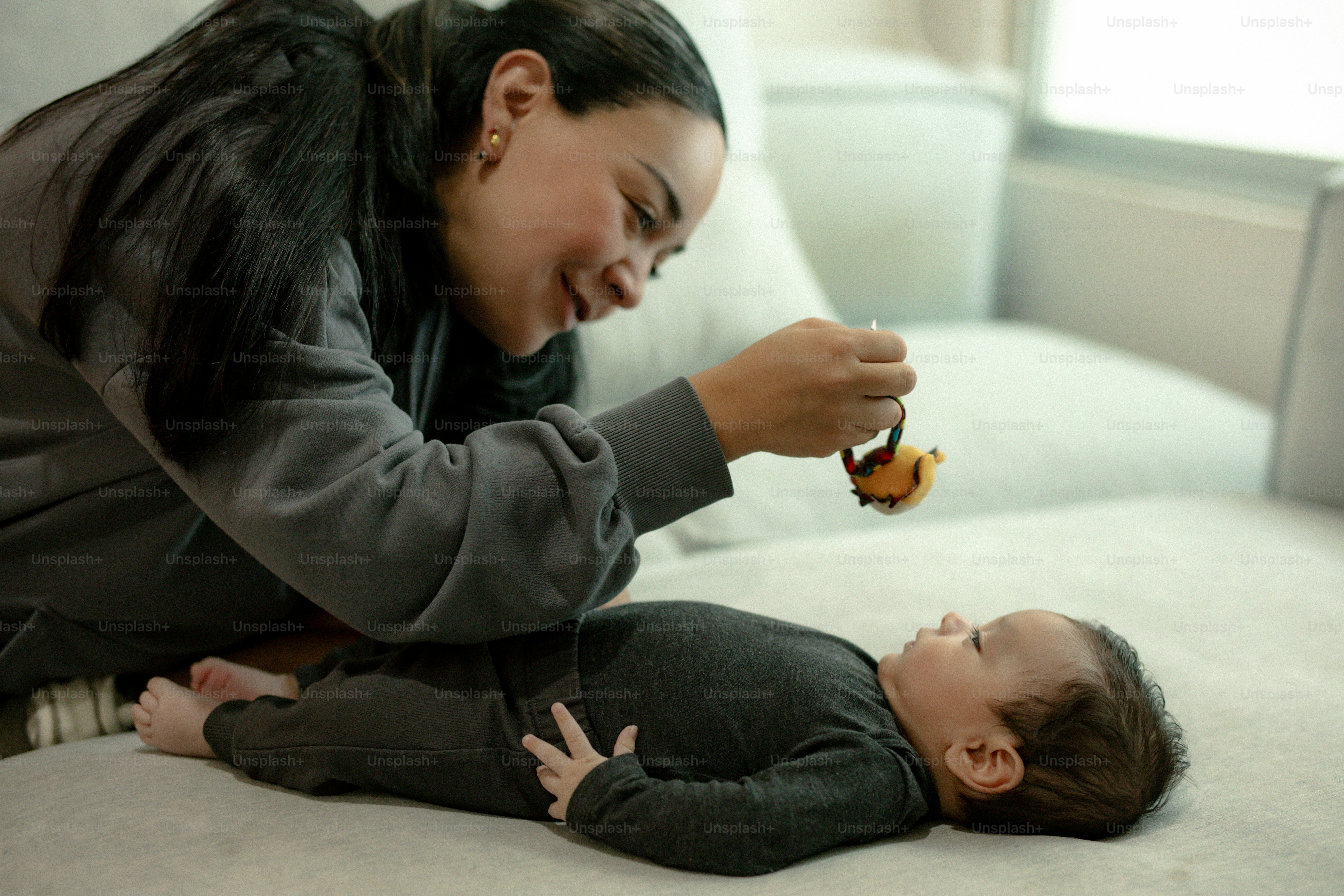 Mãe brincando com seu bebê no sofá