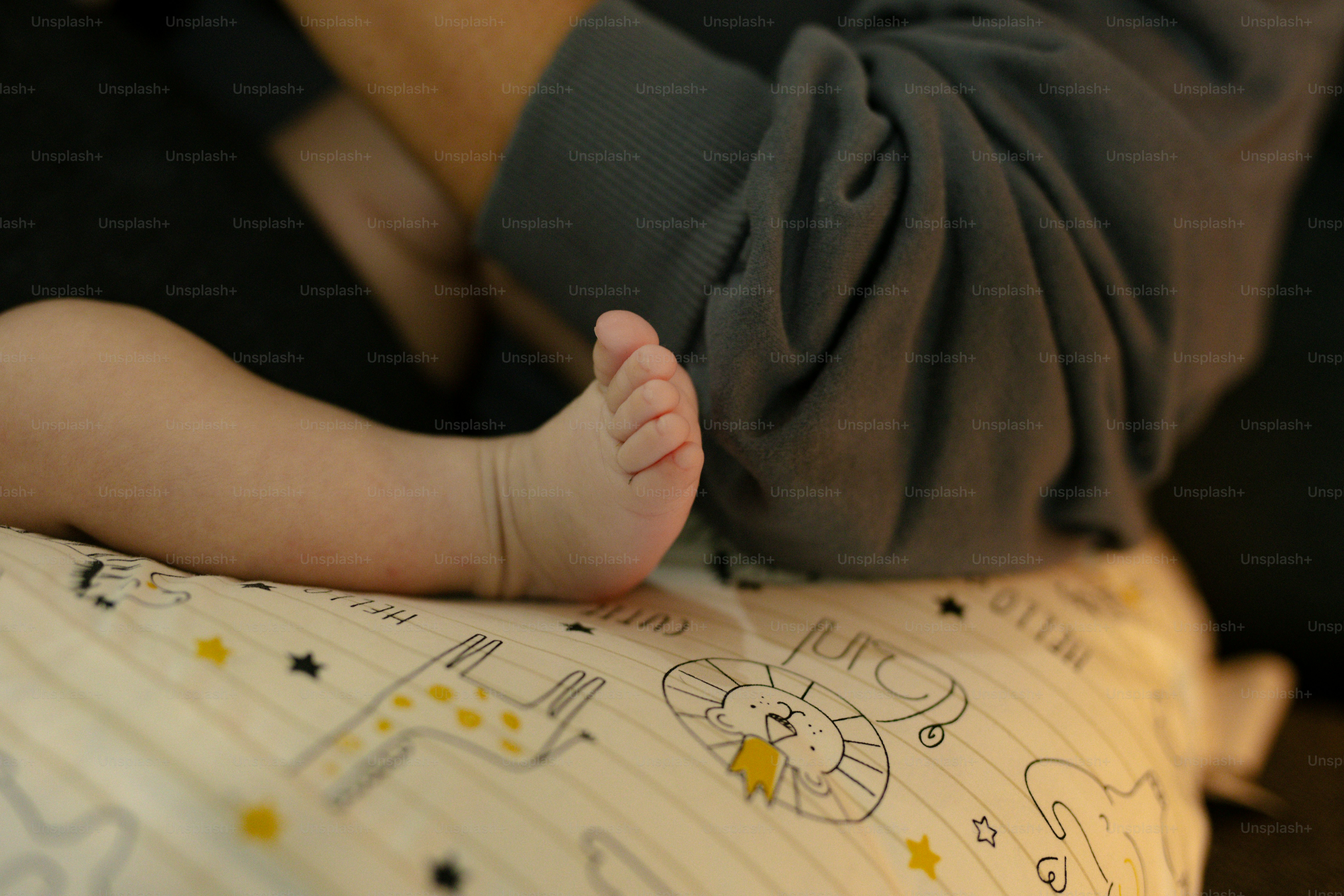 Close do pé de um bebê em um cobertor estampado.