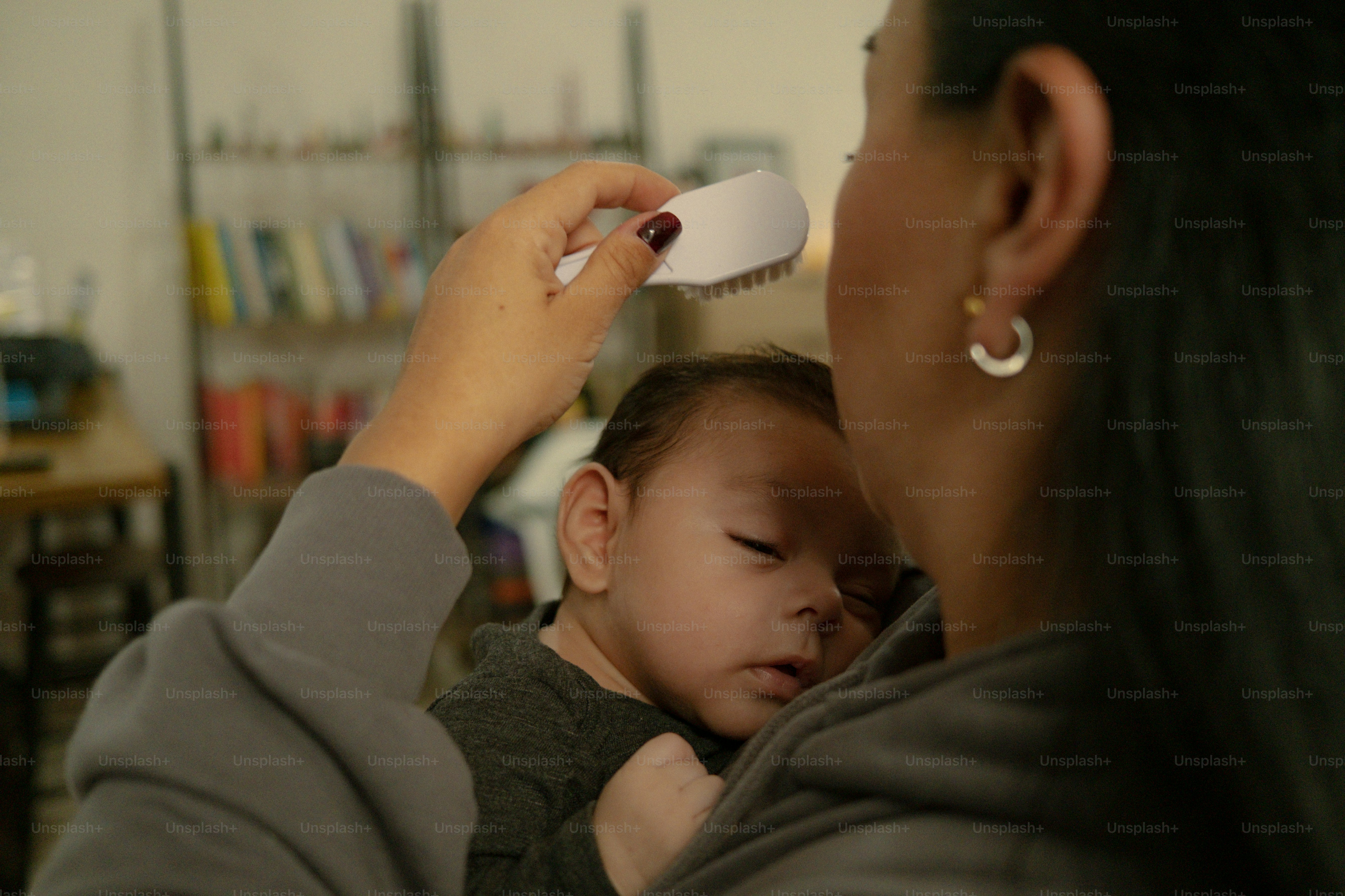 Mãe escovando suavemente o cabelo do bebê