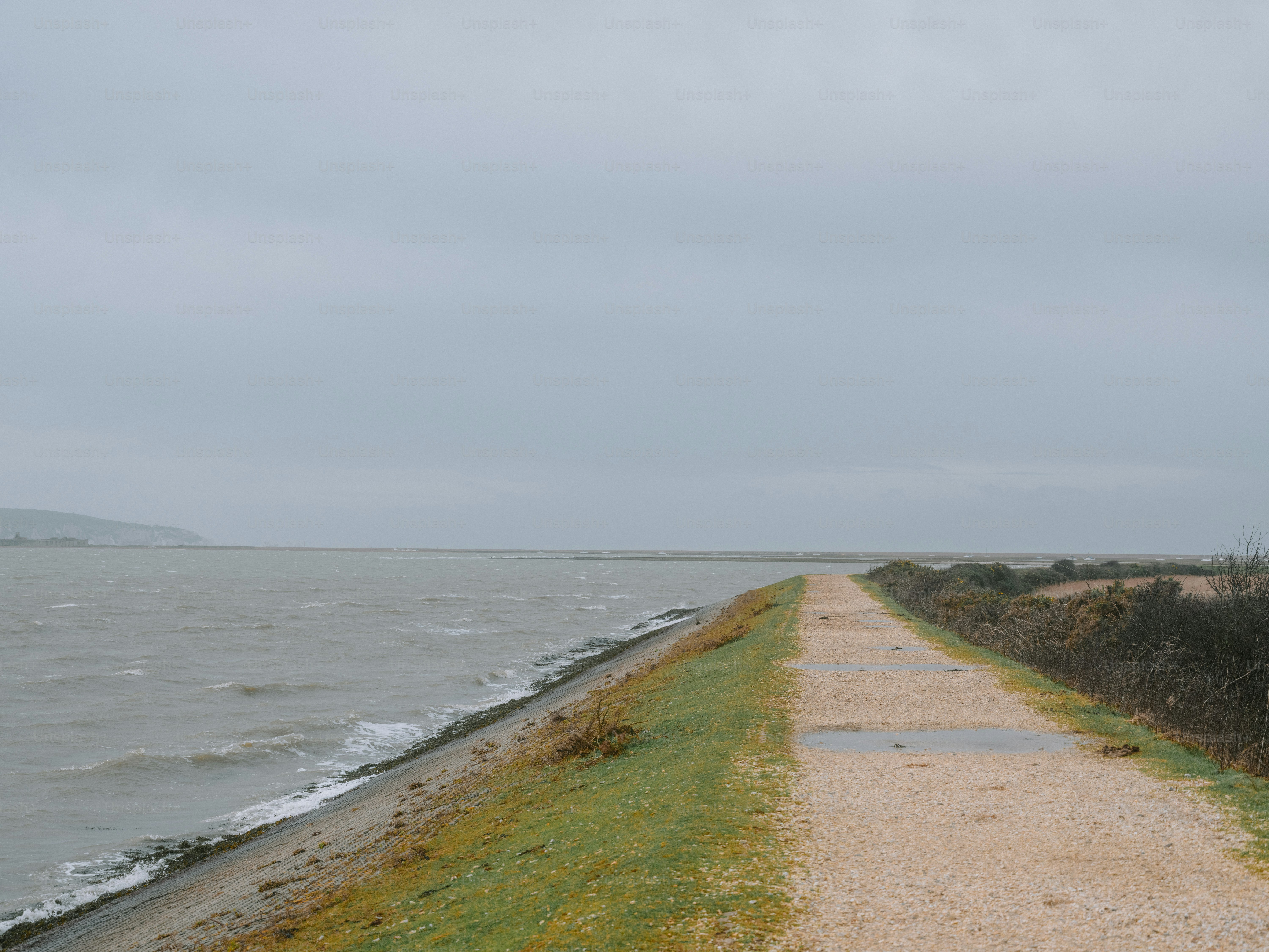 Un sentiero asfaltato corre lungo un specchio d'acqua