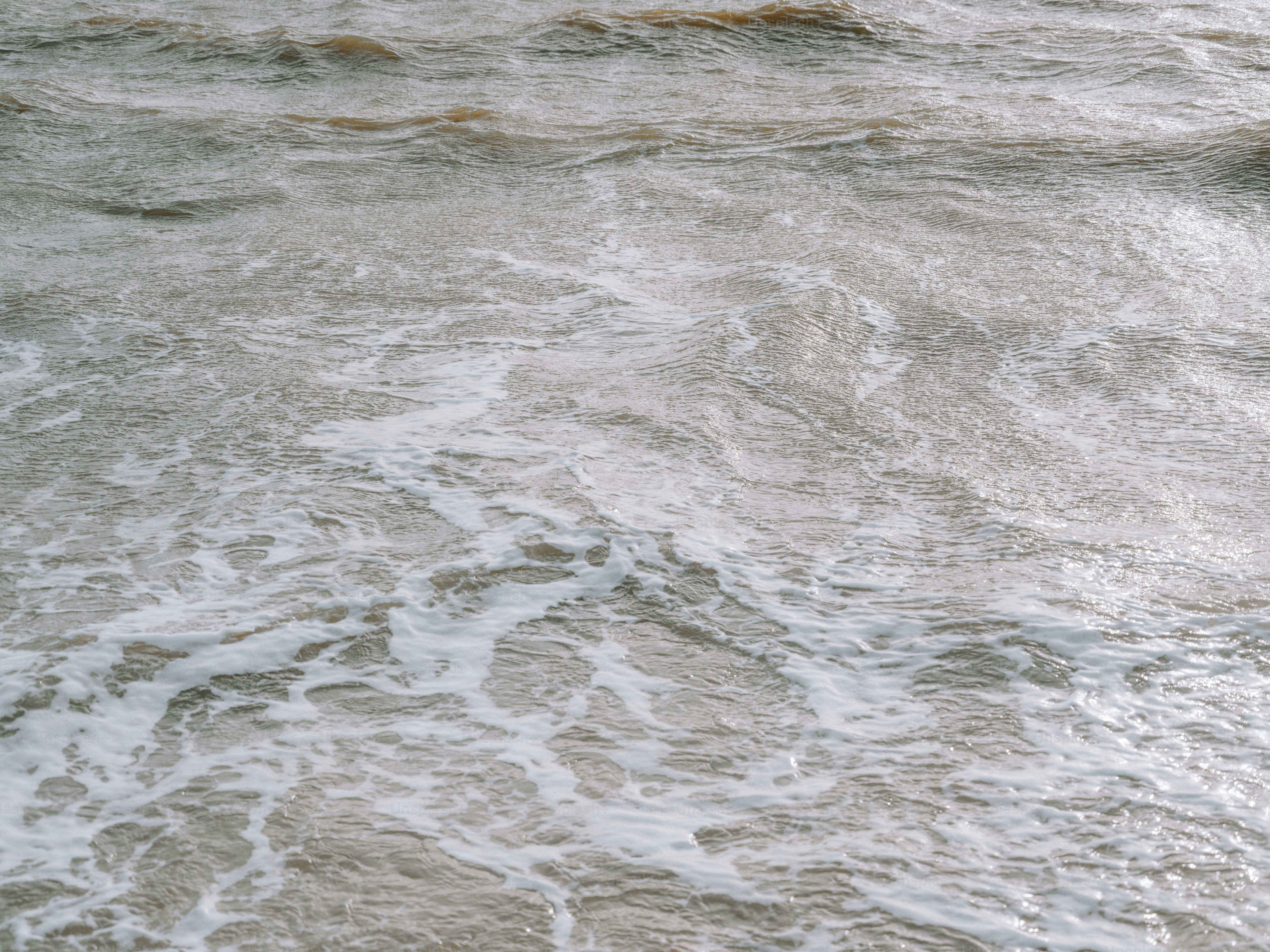 Onde dell'oceano con schiuma bianca che si infrangono sulla riva