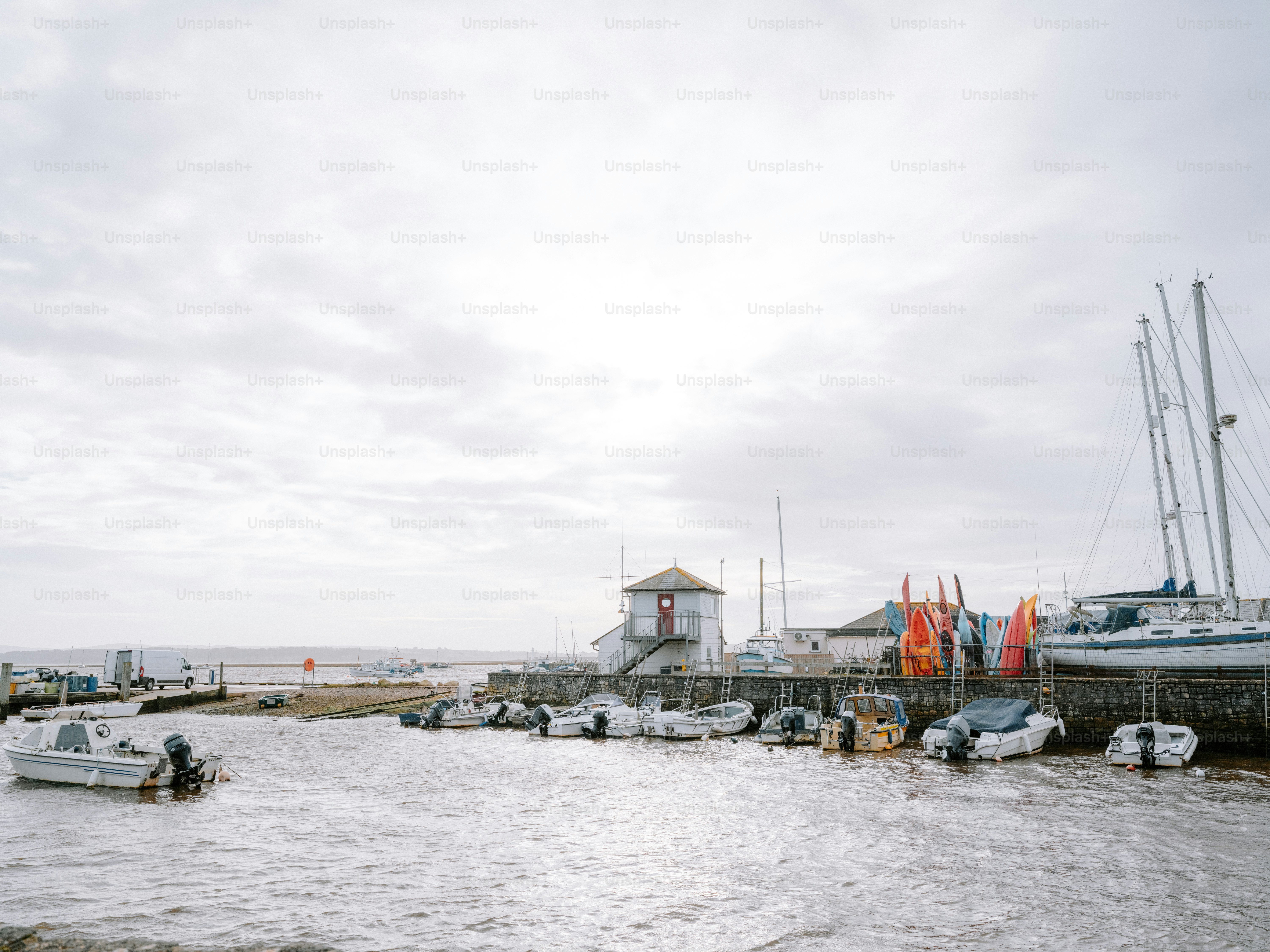 Boats docked at a harbor under a cloudy sky