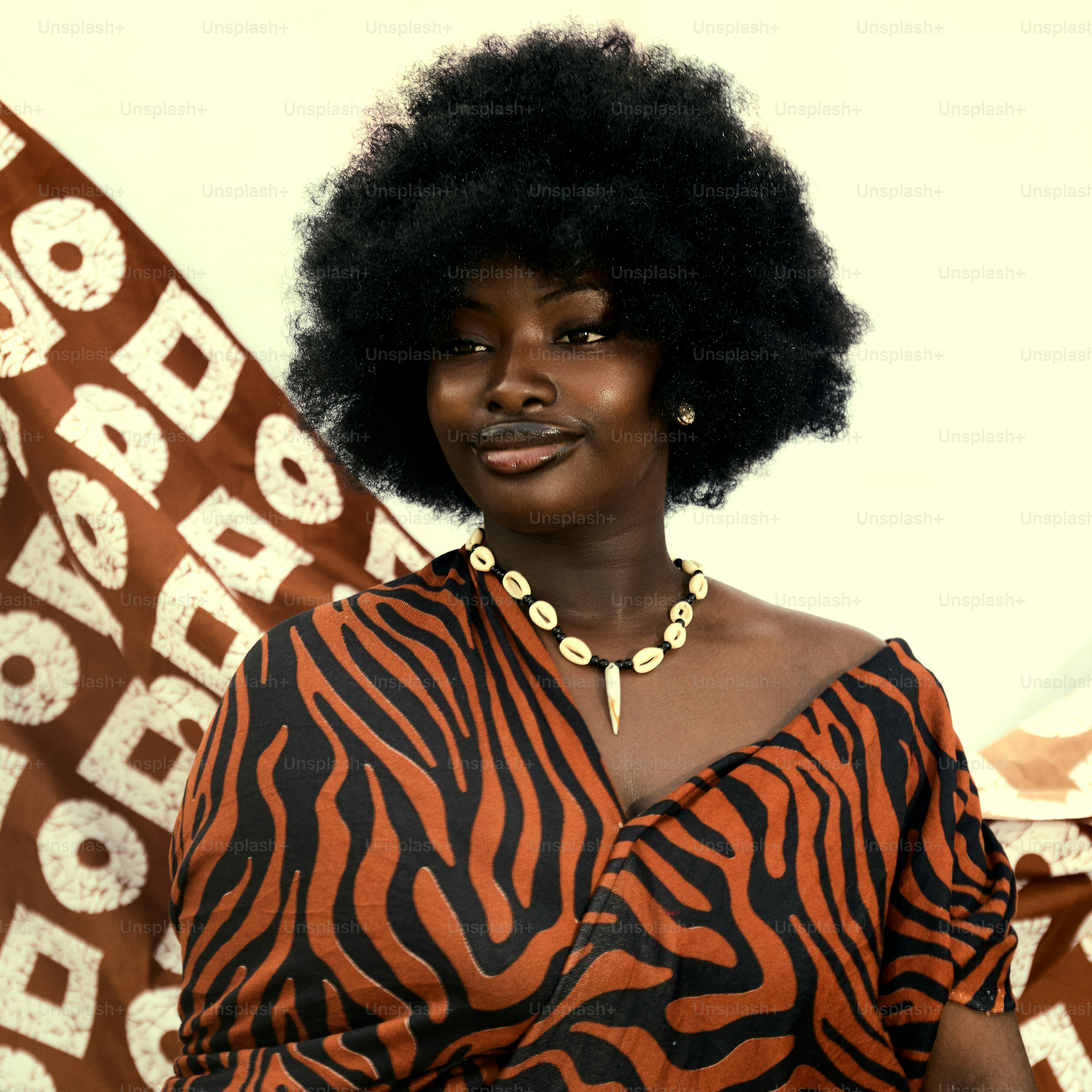Une femme noire avec un afro porte des vêtements à imprimé tribal.