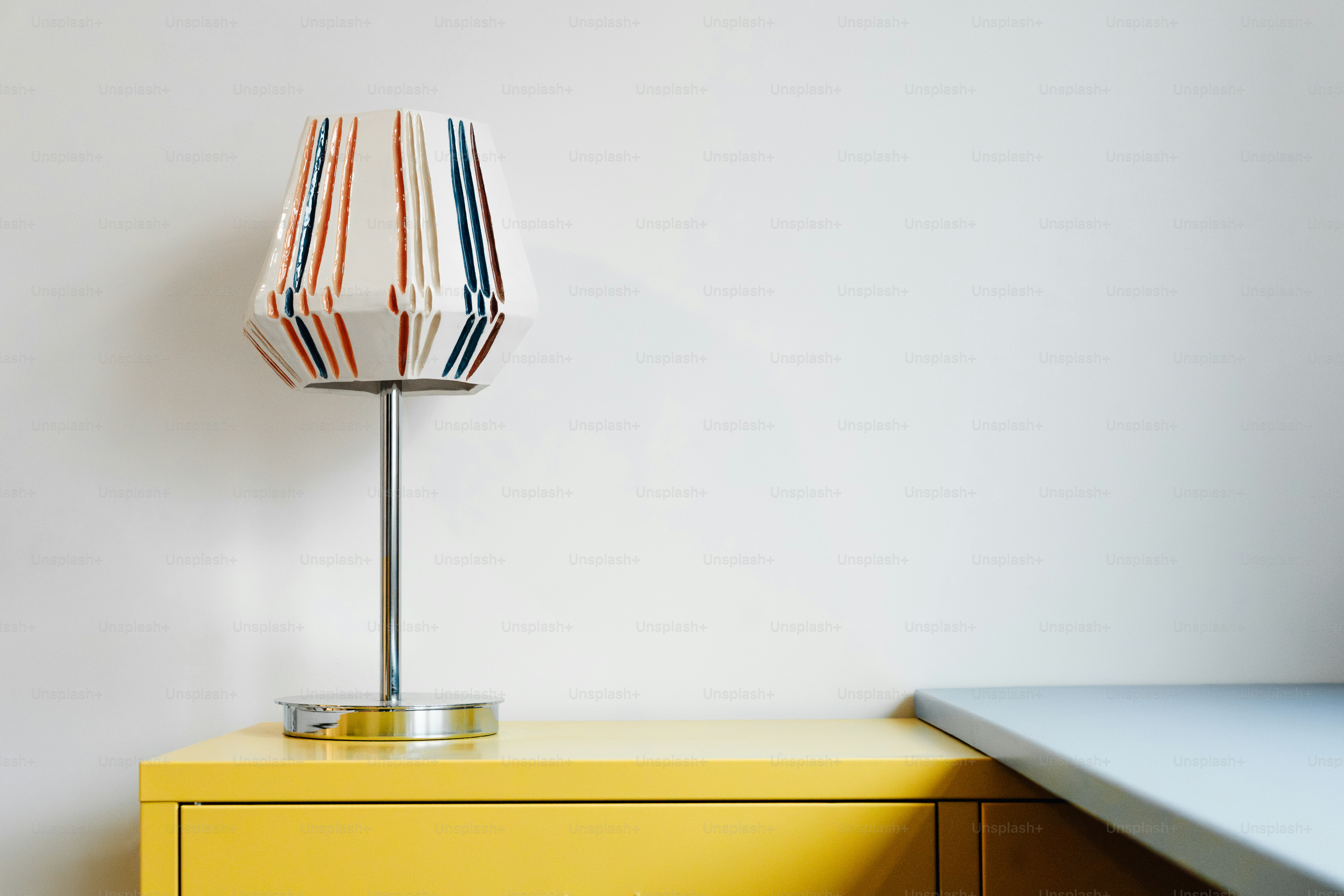Striped lamp on a yellow cabinet