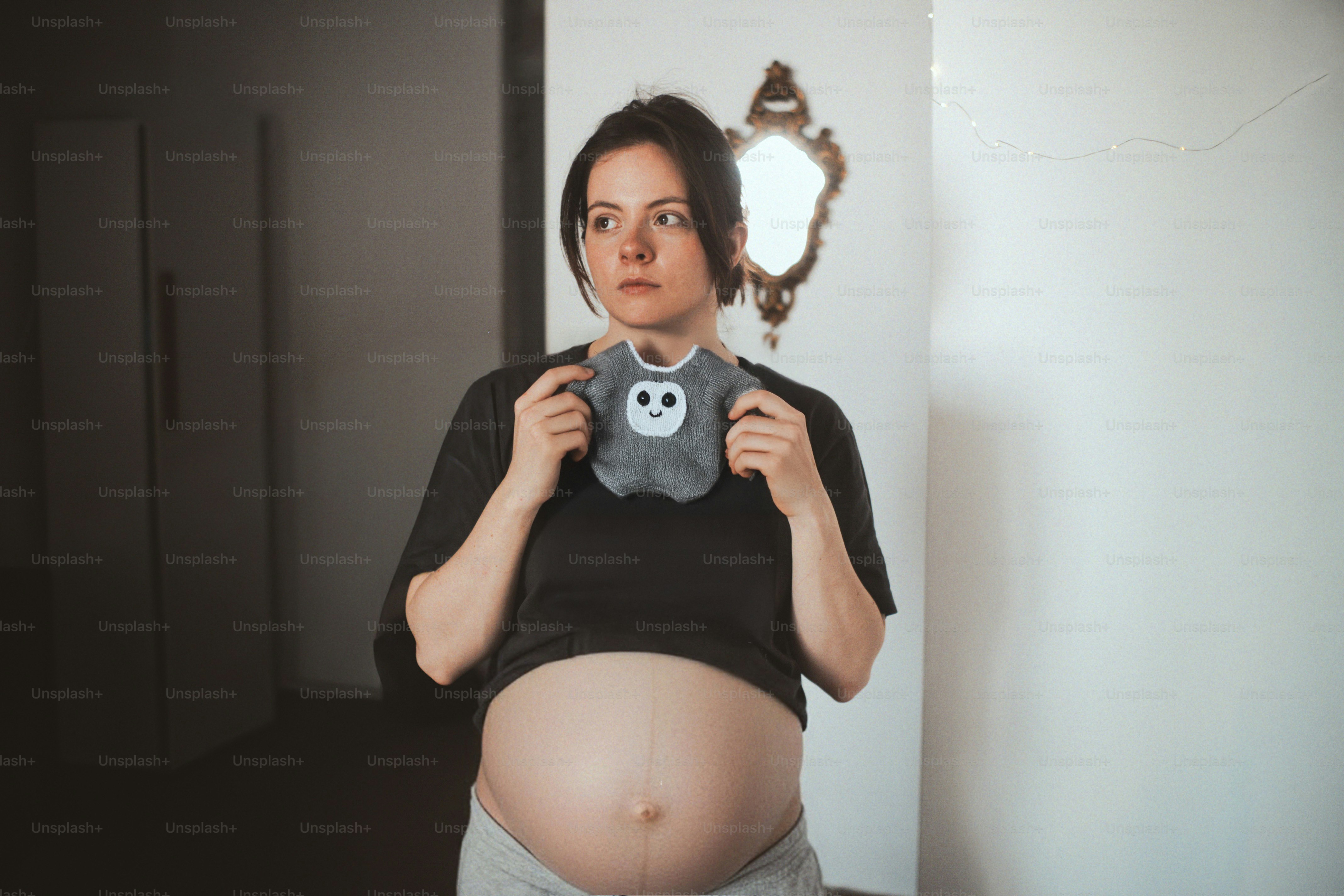 Pregnant woman holding a stuffed toy over her belly