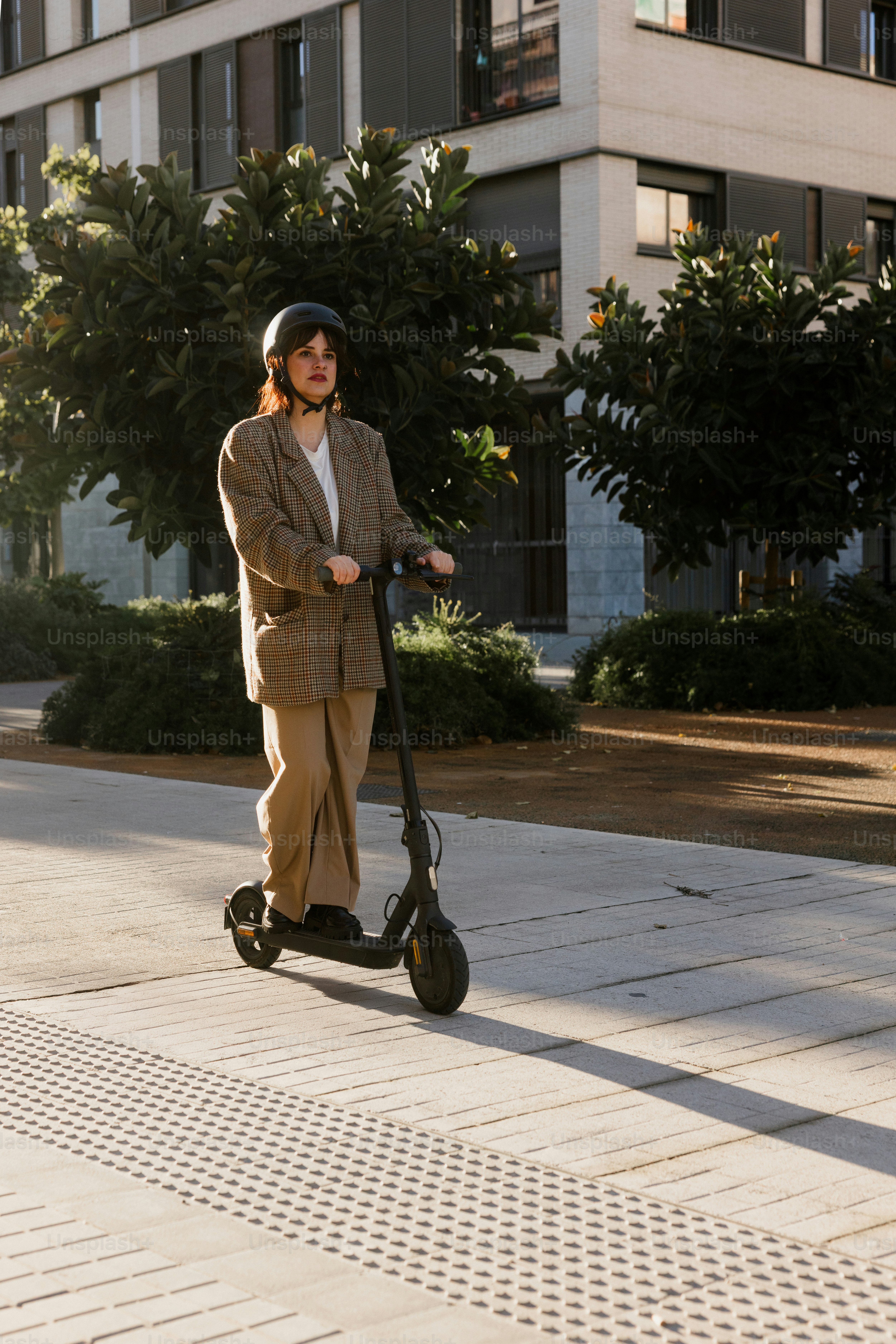 Woman riding an electric scooter on a sunny day.