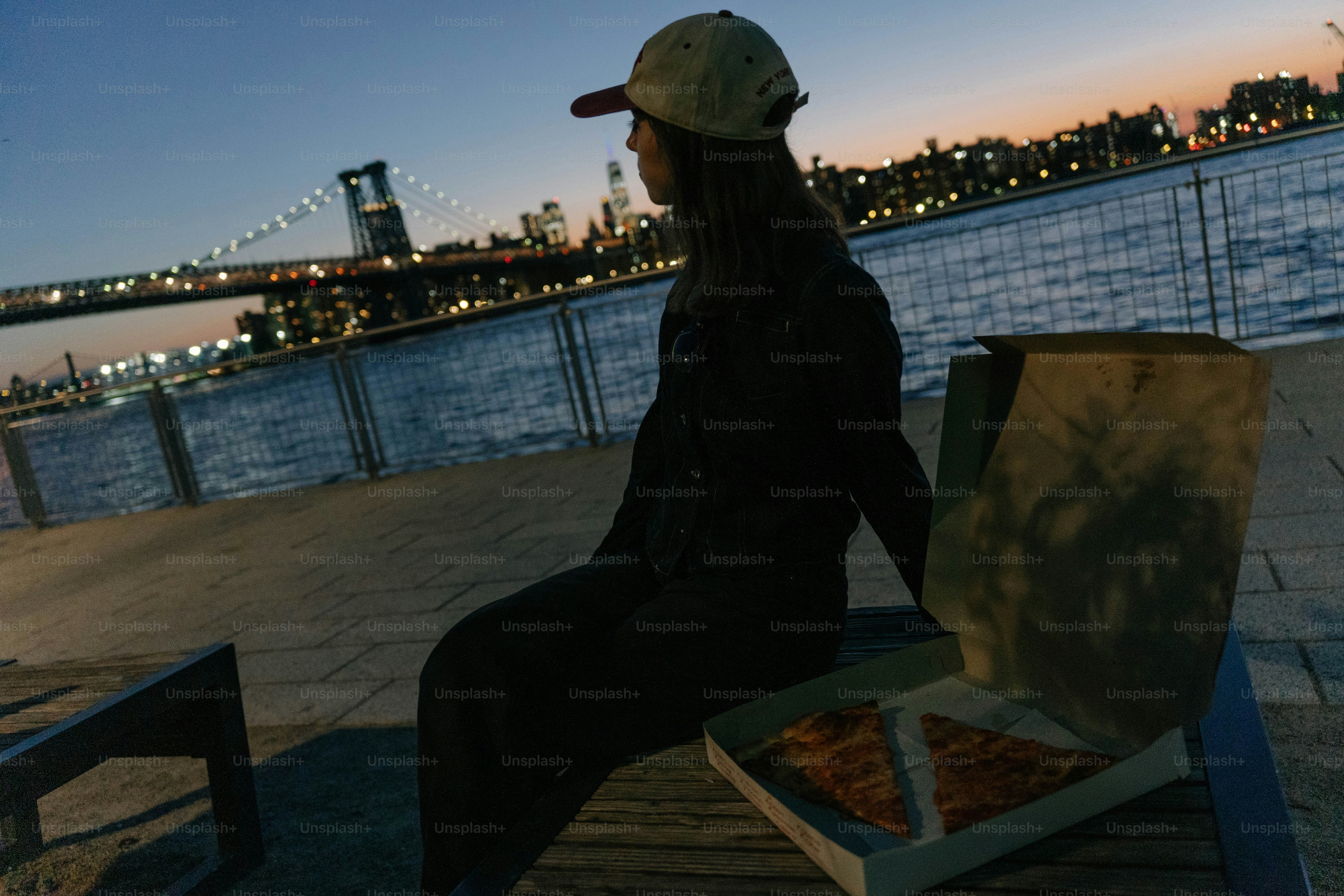 해질 무렵 물가에 피자를 든 여자