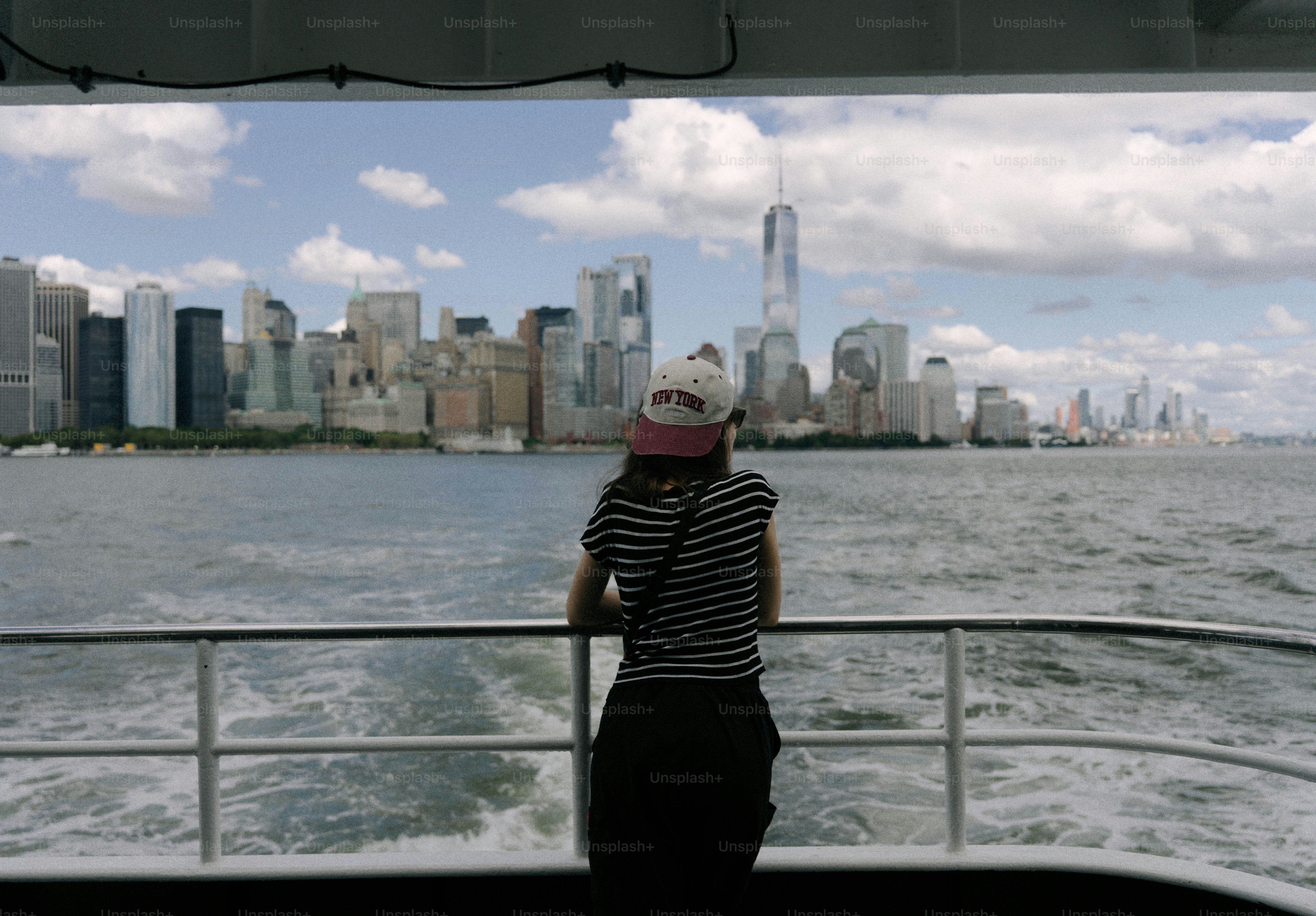 배 위에서 뉴욕시 스카이라인을 바라보는 여성