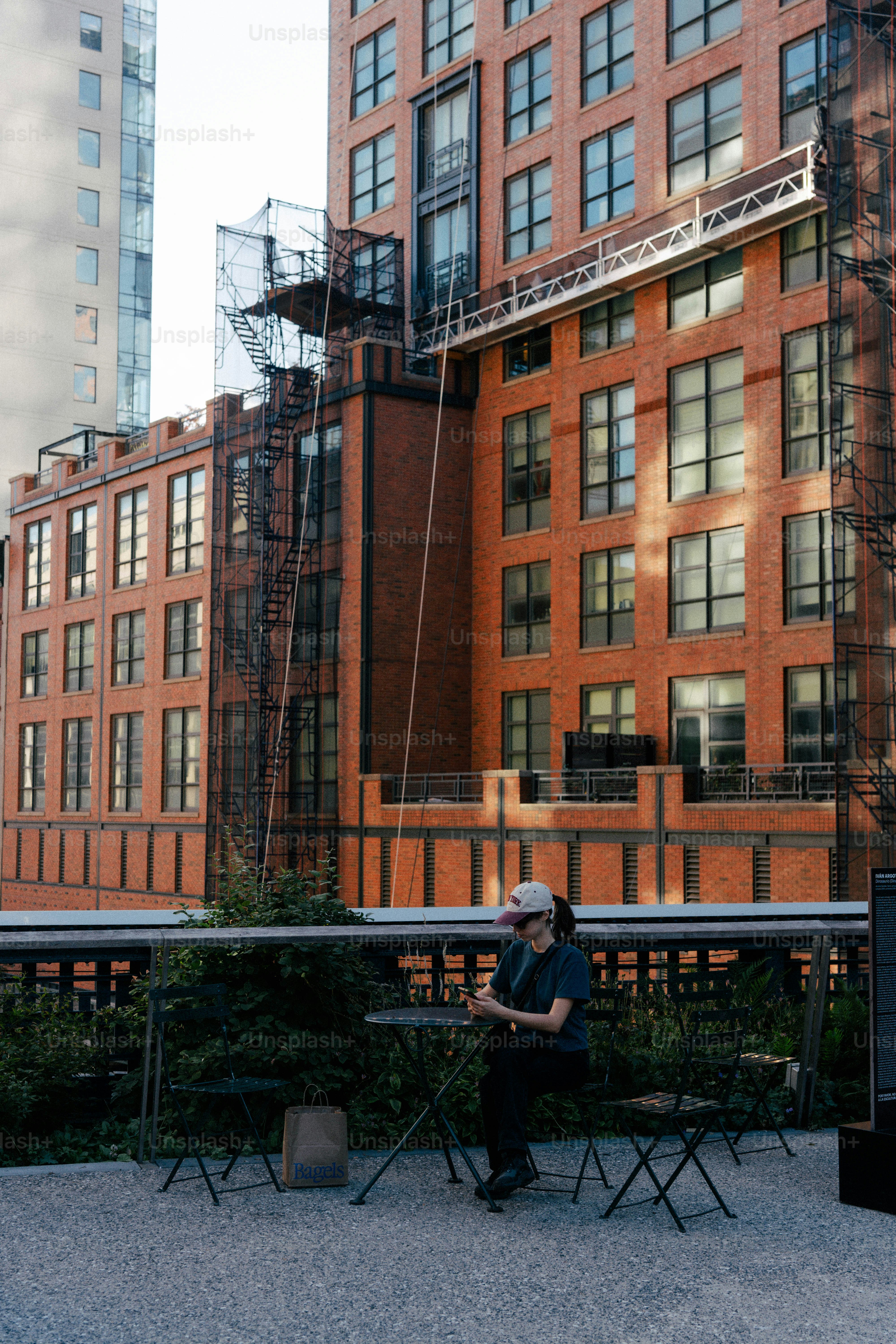 벽돌 건물 밖 탁자에 앉아 있는 여성