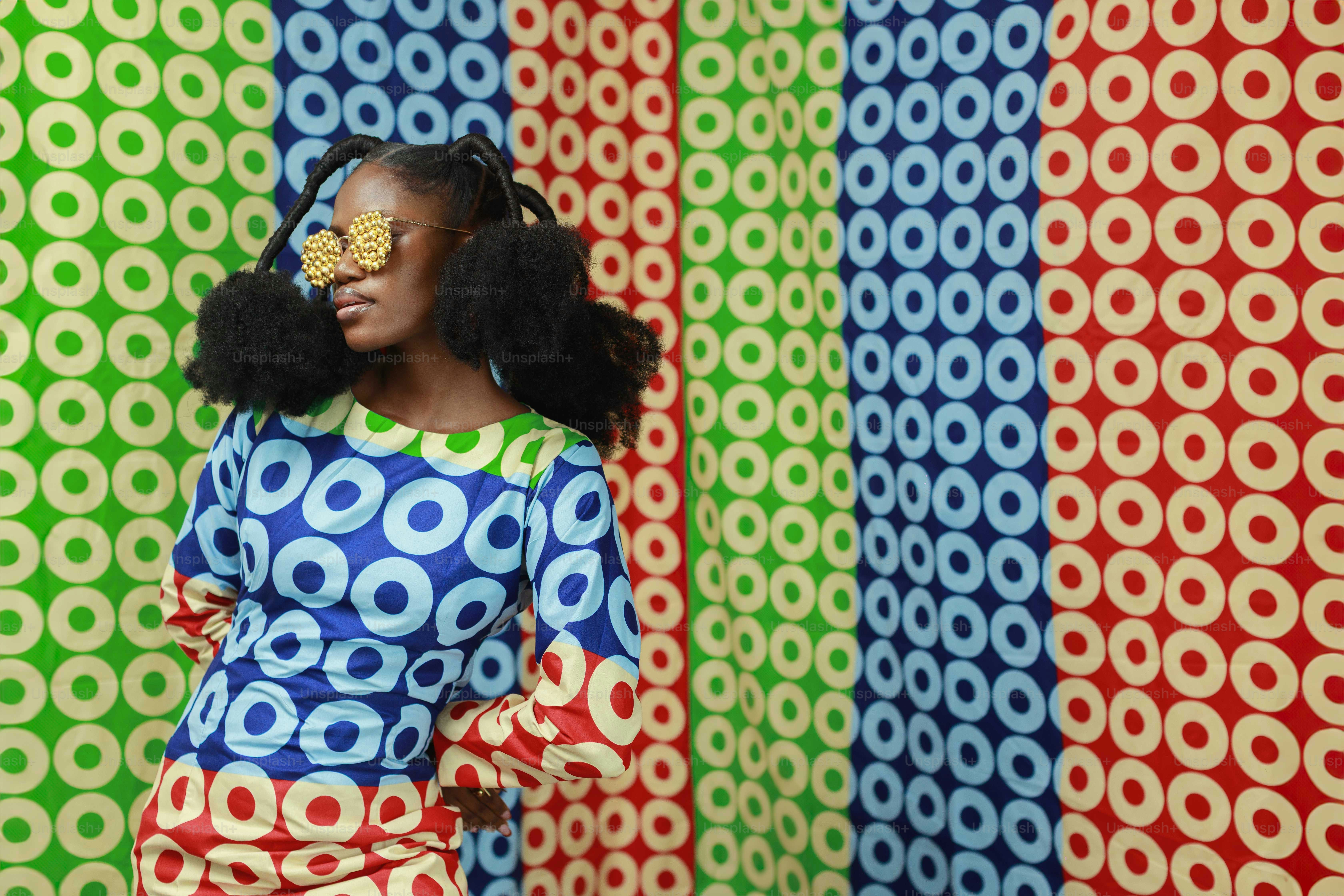 Woman in colorful patterned outfit against a patterned background photo ...