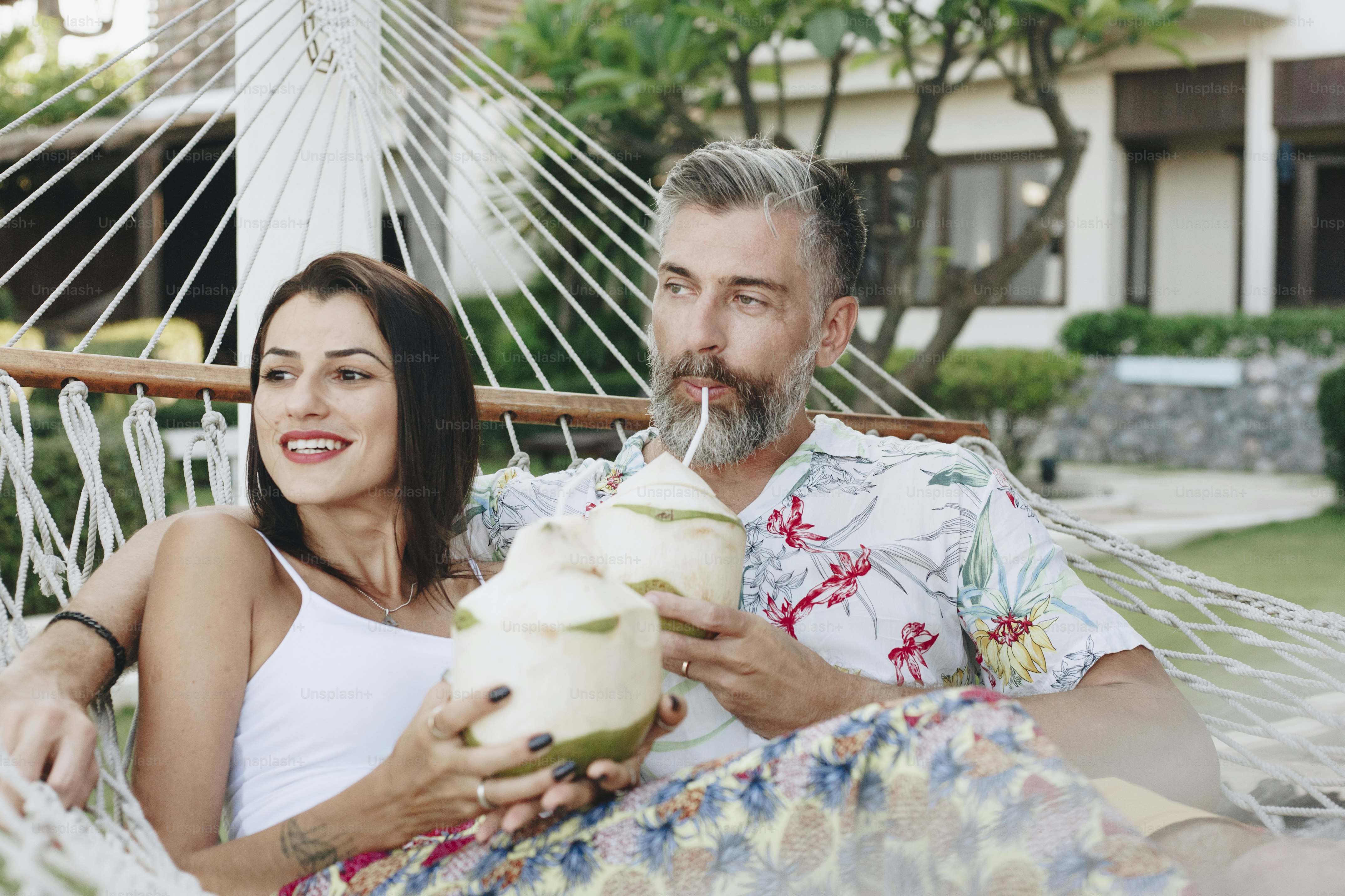 Couple drinking coconut juice in a hammock