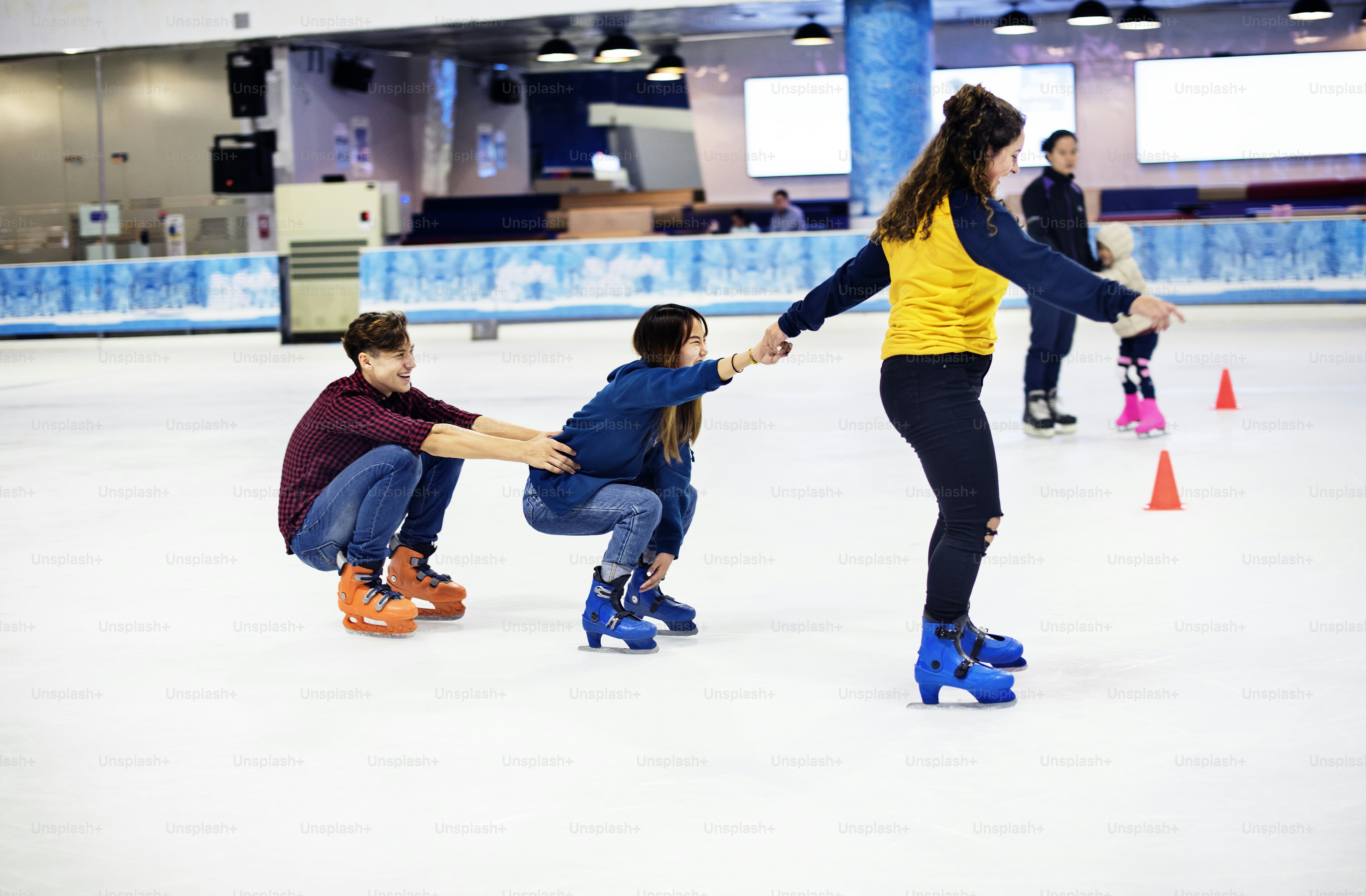 Group of teenage friends ice skating on an ice rink