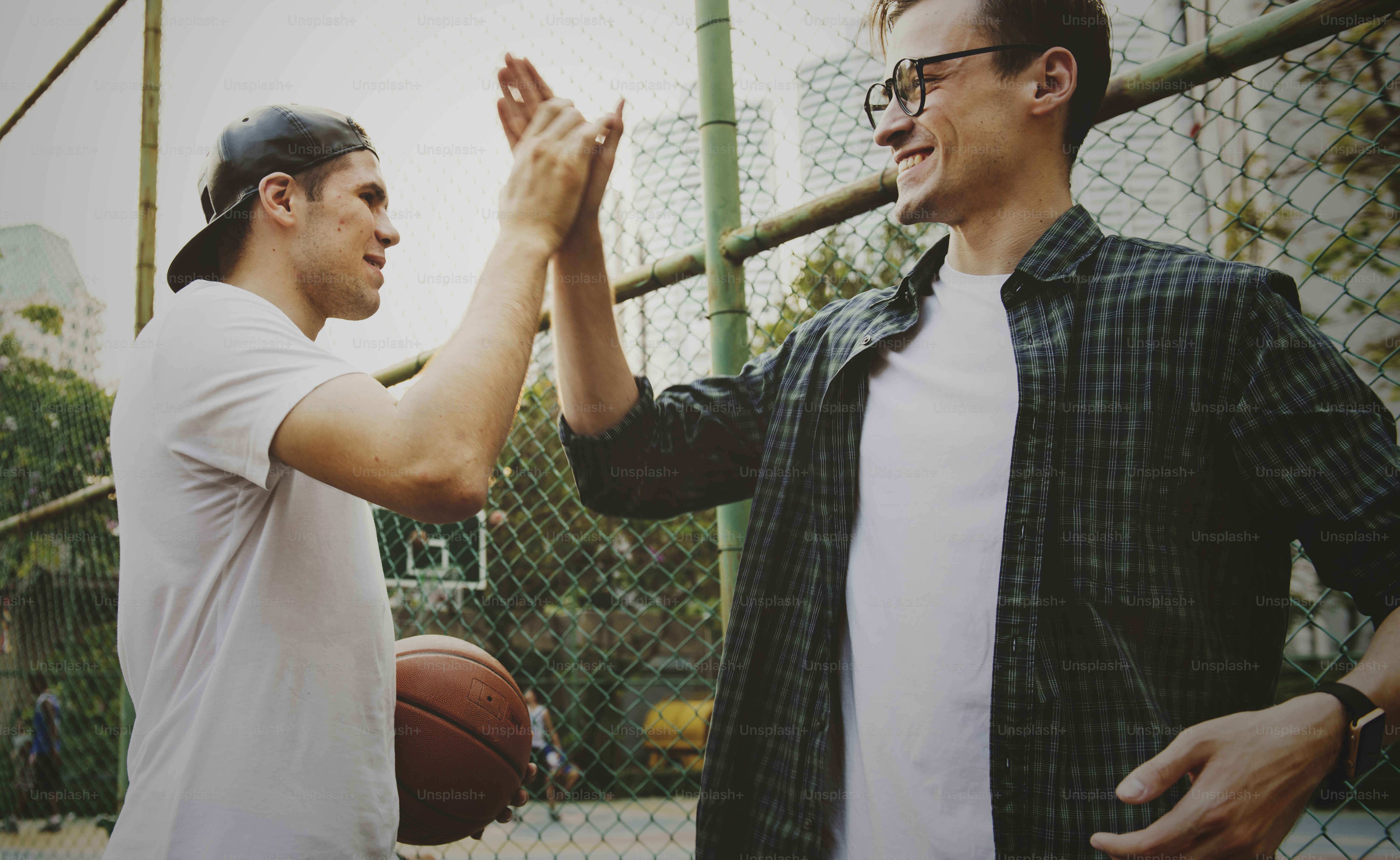 Young adult male friends playing basketball in the park