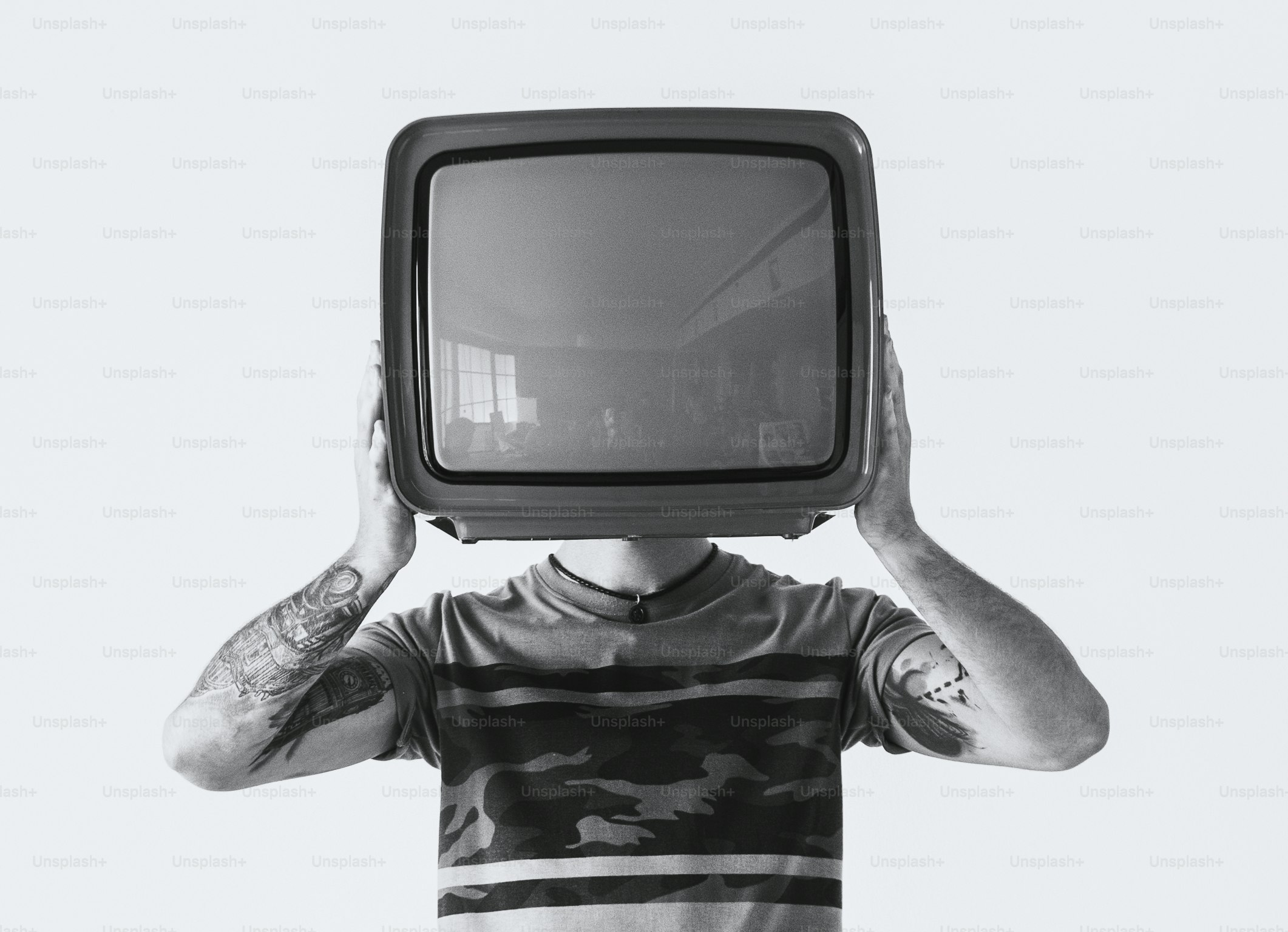 Person mit Tattoo, die den Fernseher hält