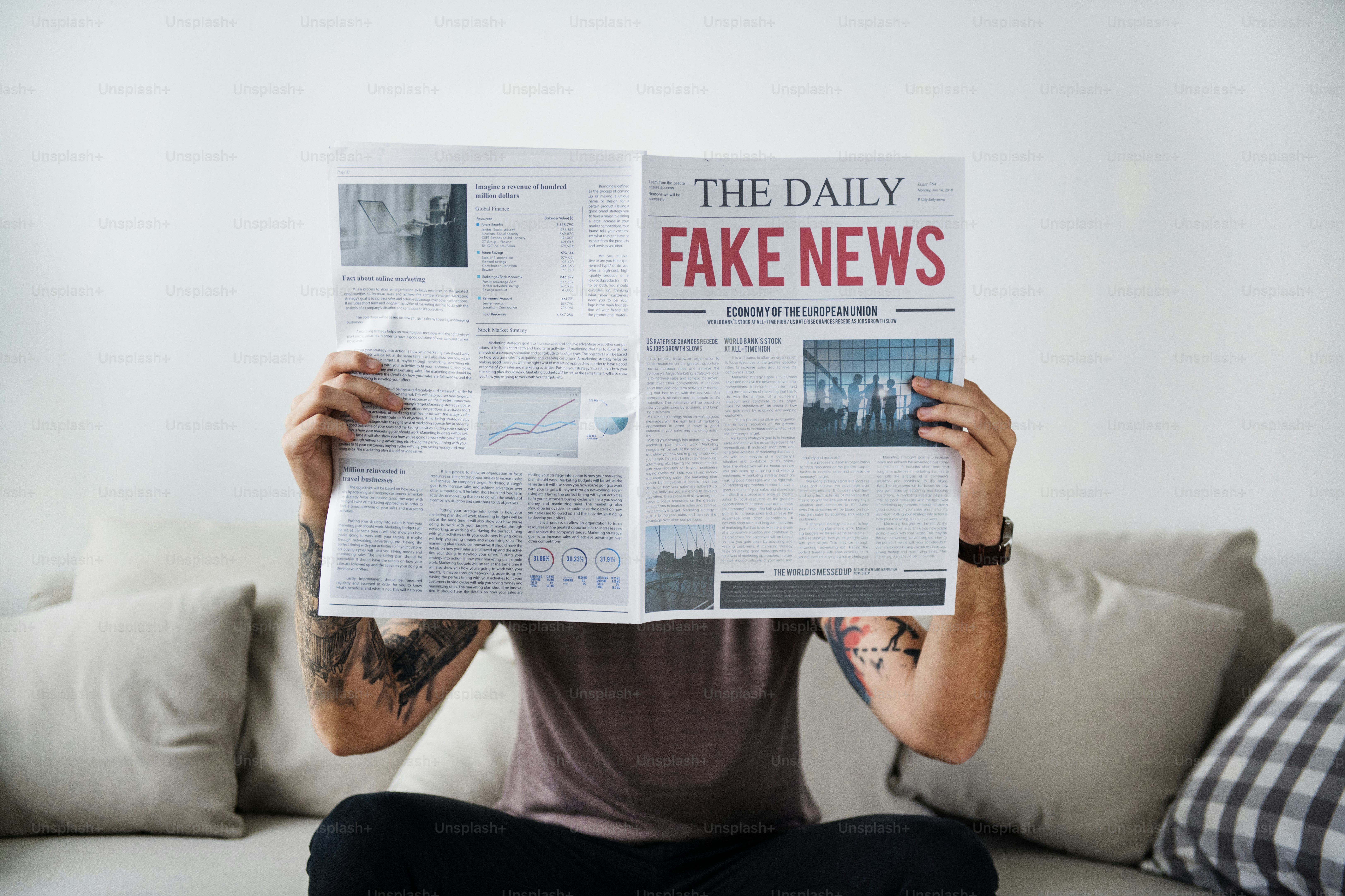 A person holding a newspaper with the headline THE DAILY FAKE NEWS