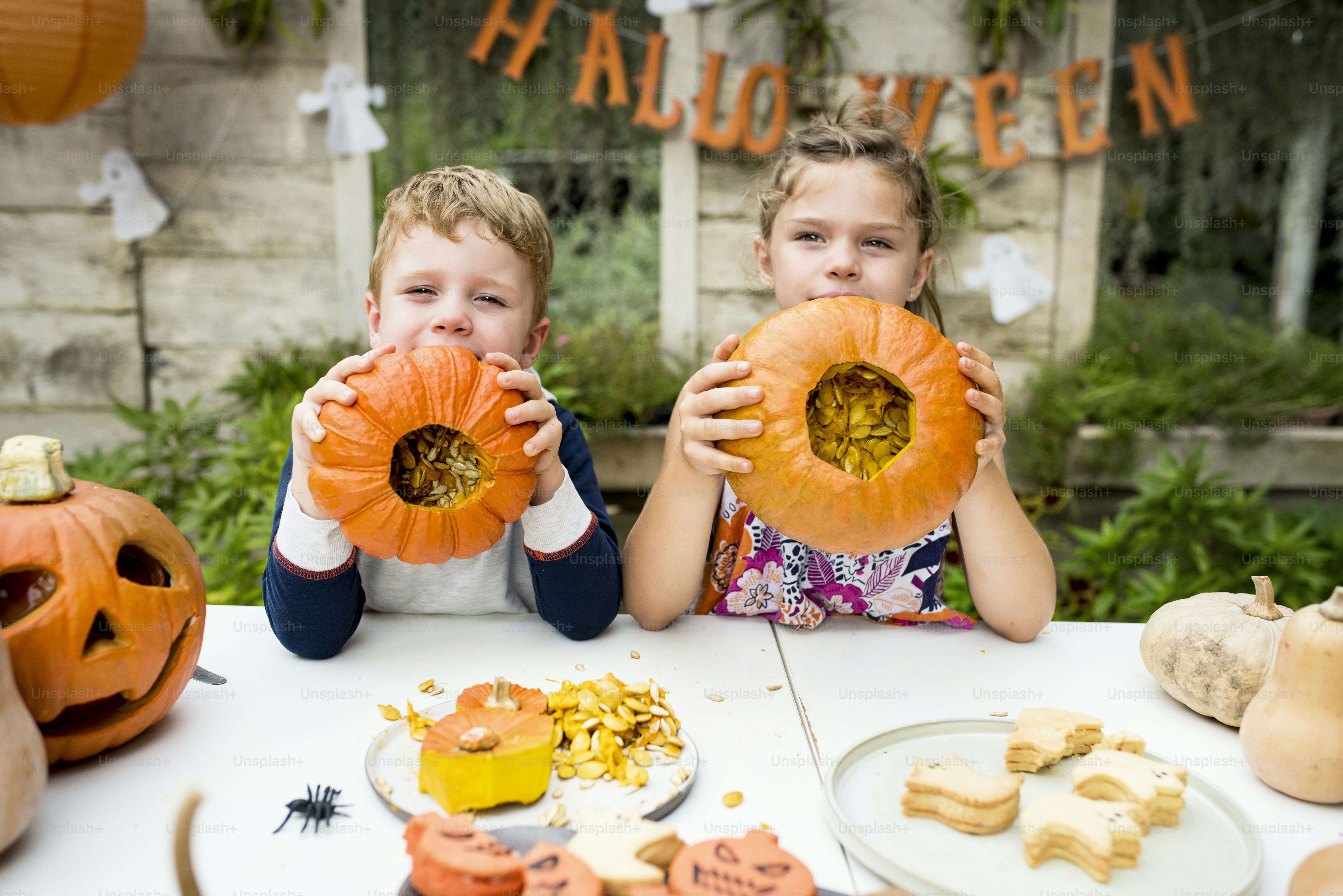 De jeunes enfants sculptant des citrouilles-lanternes d'Halloween