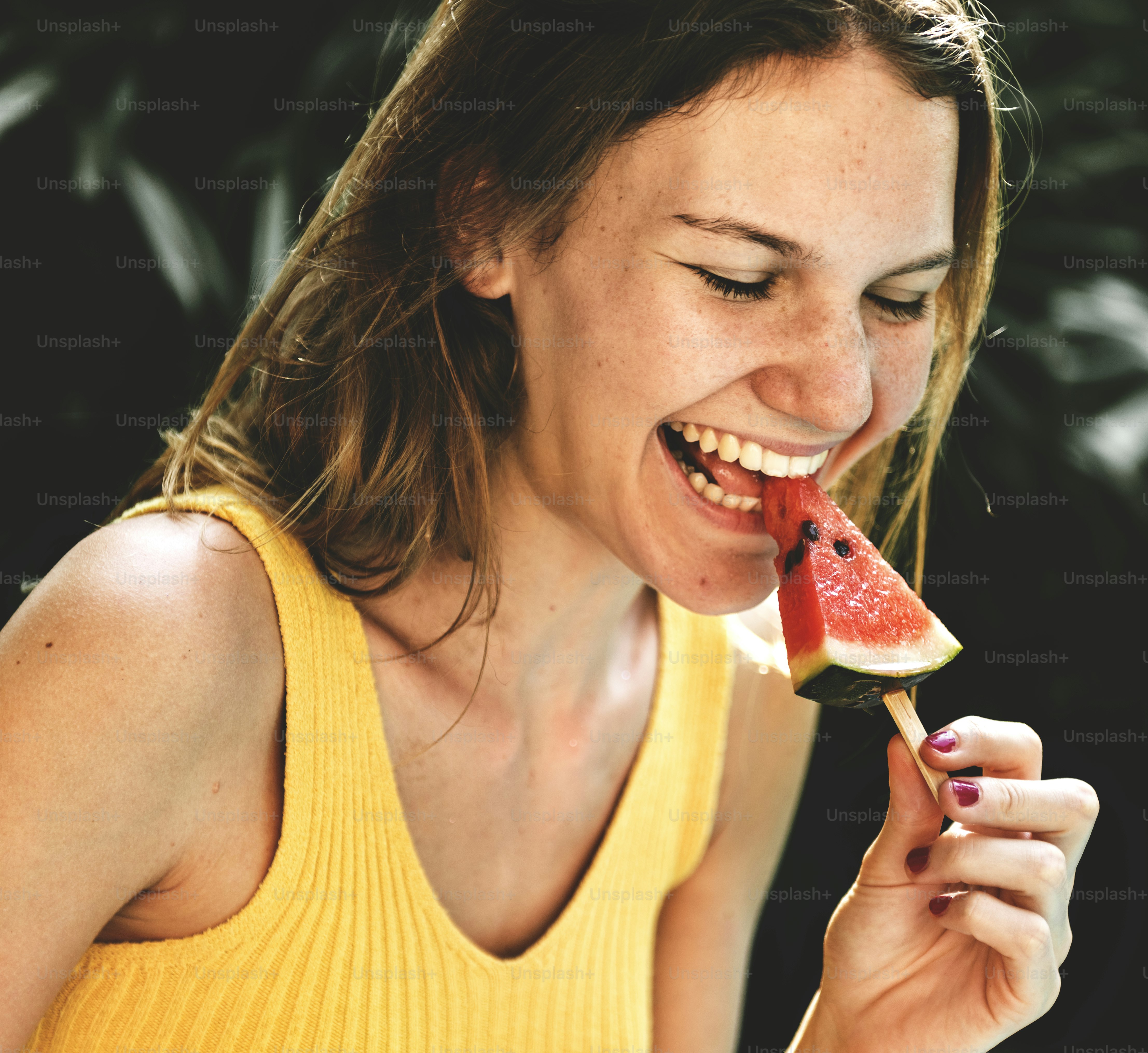 Caucasian woman eating watermelon in summertime