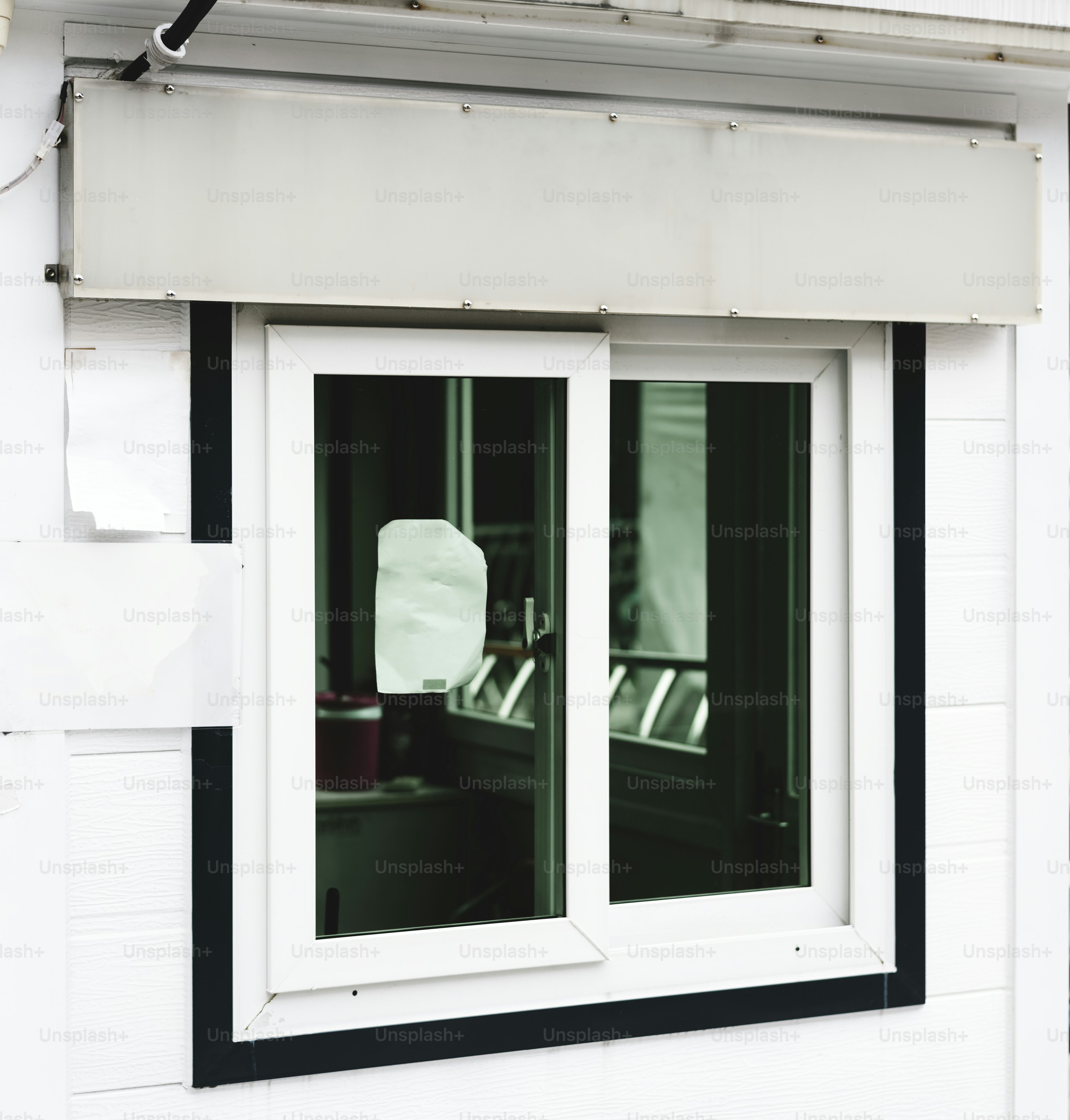 A white shop signage mockup above a shop window