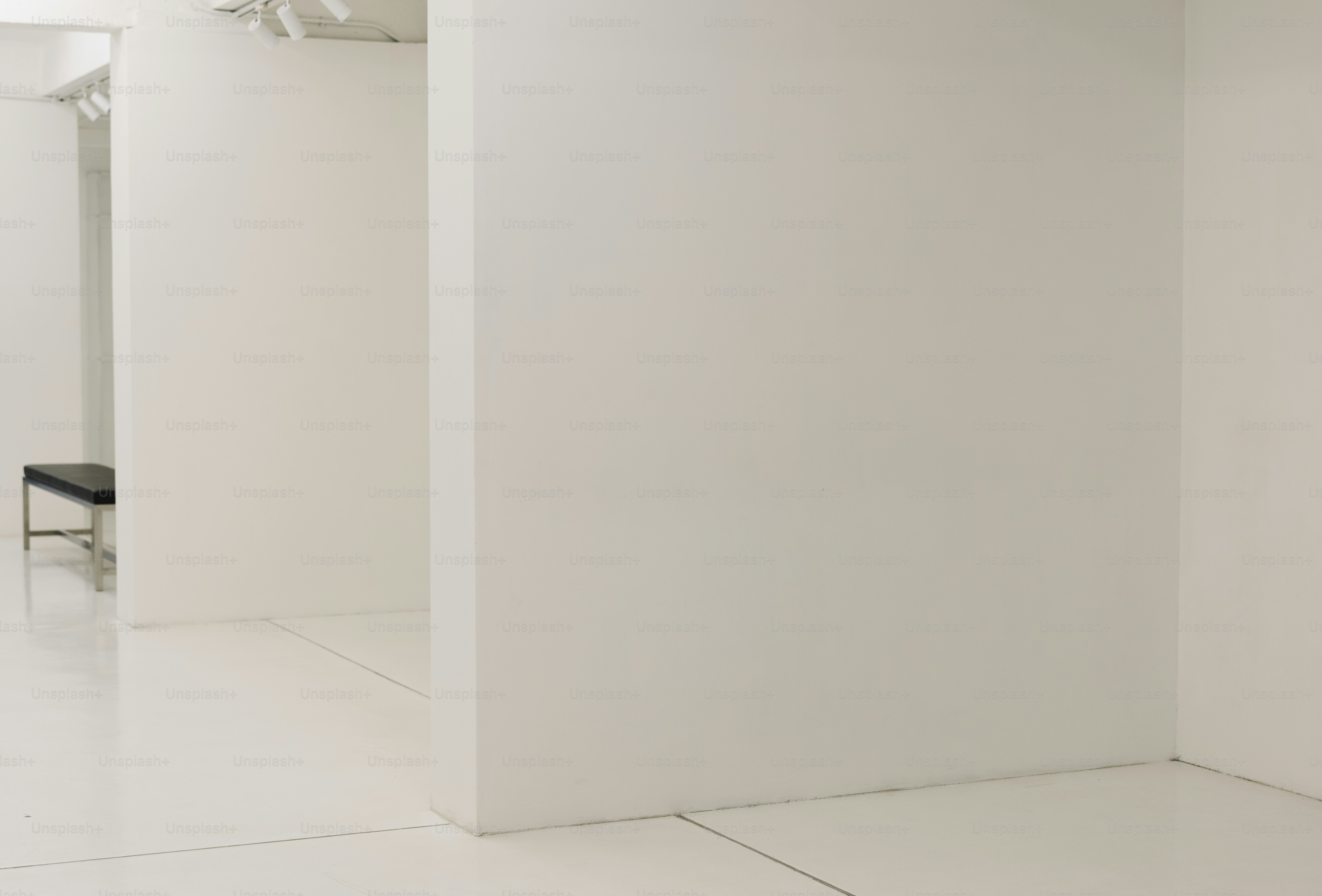 White exhibition room with a bench