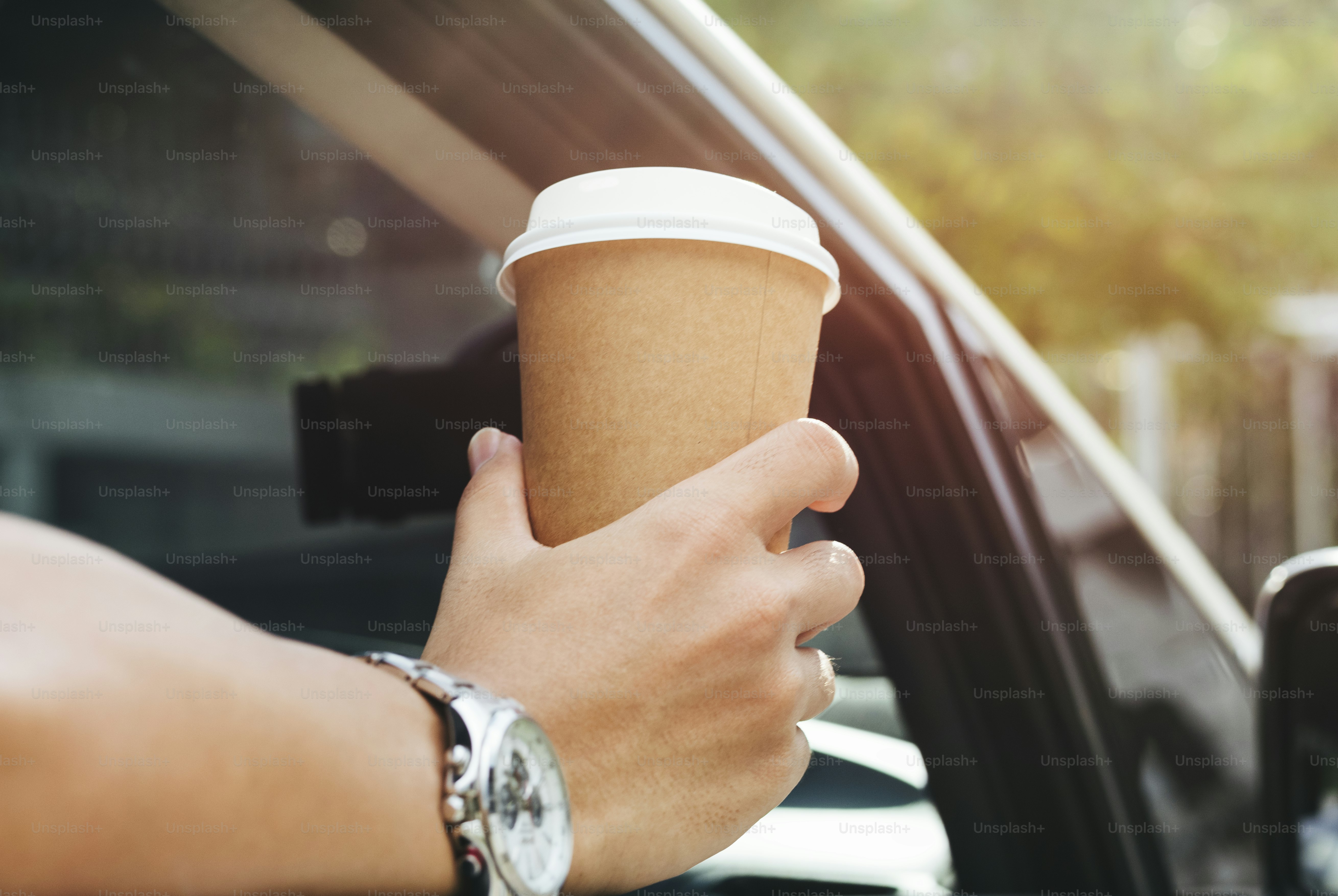 Tenir la main du café à emporter dans une voiture