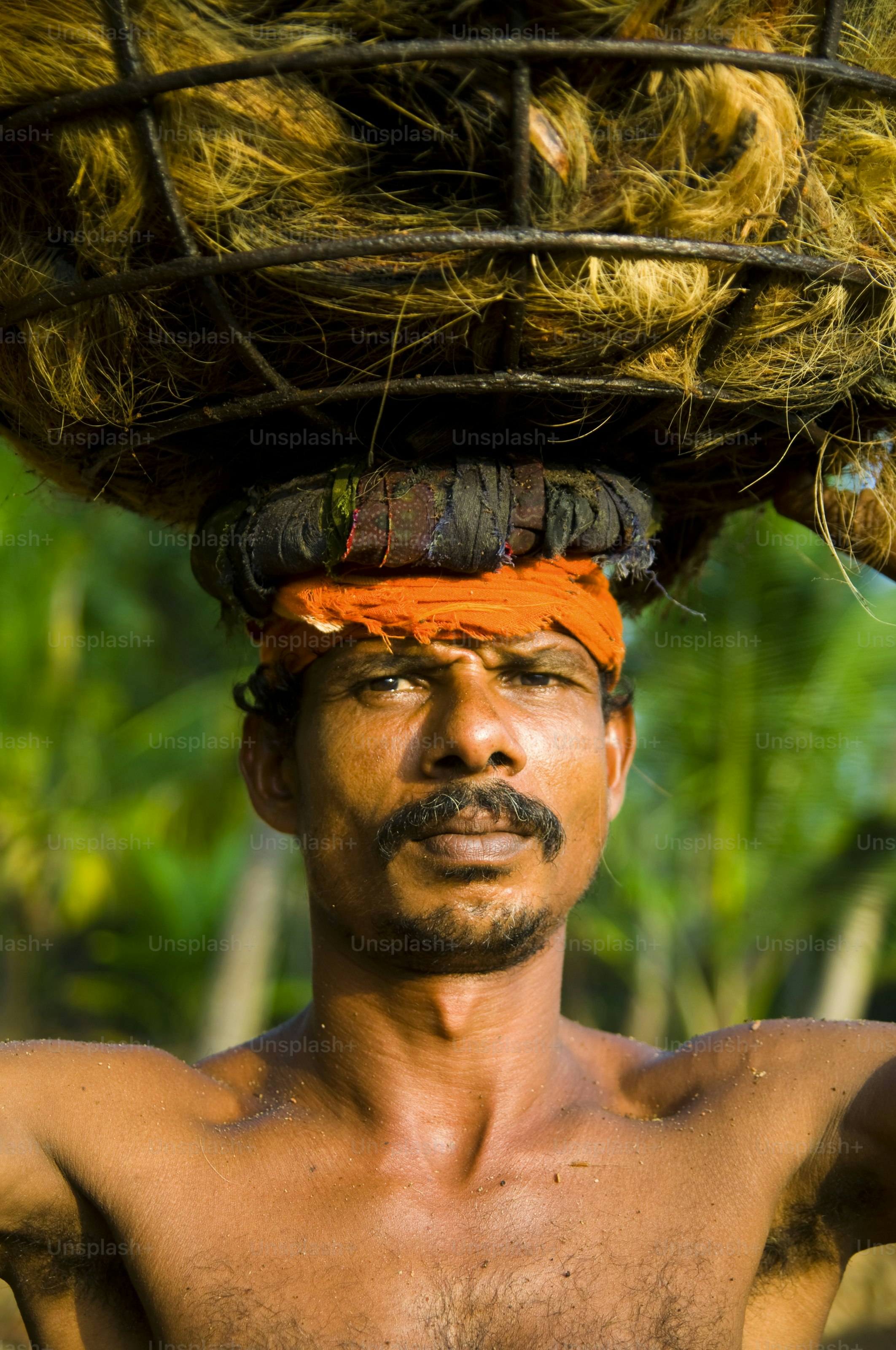 Man carrying heavy load of hay on head