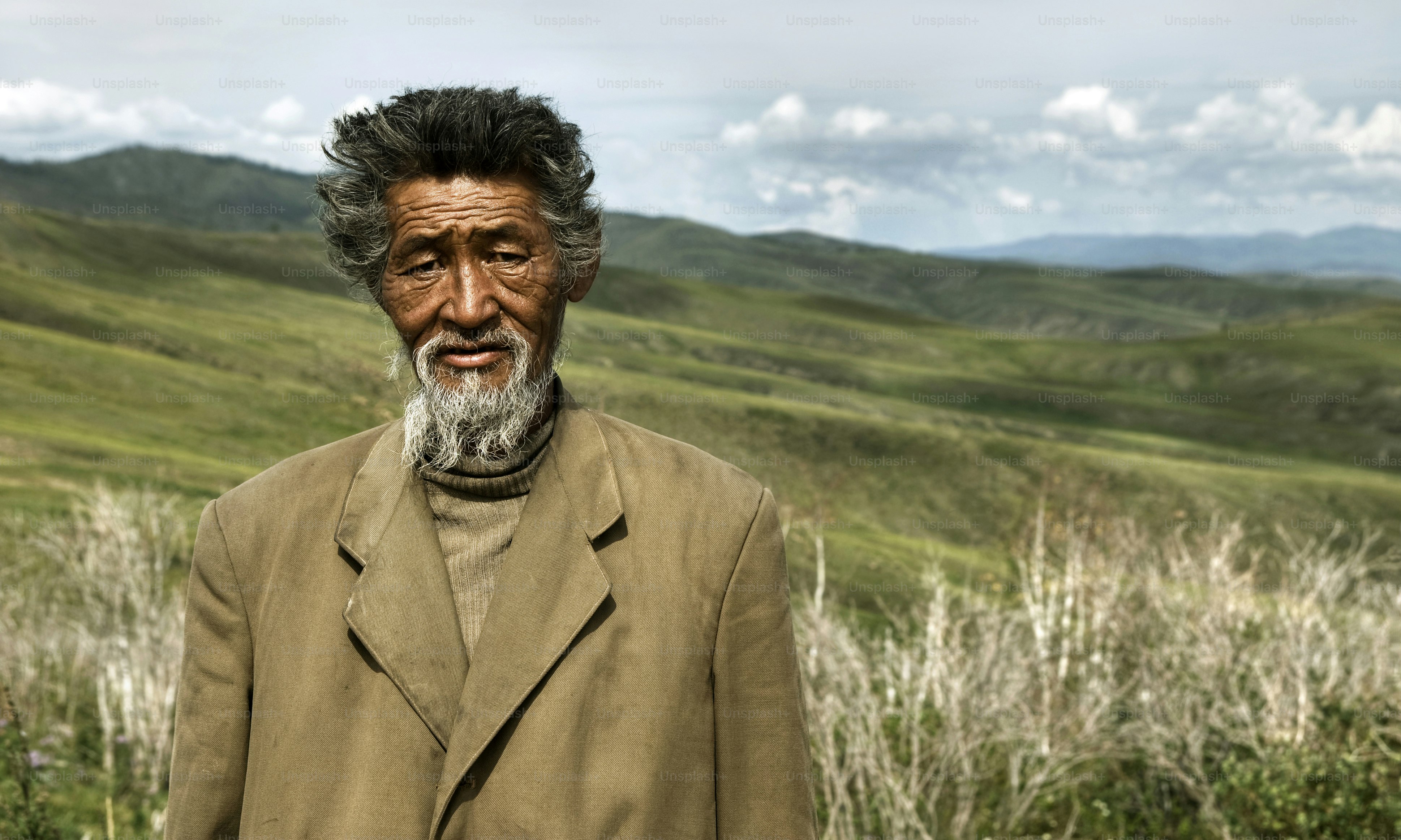 Hombre mayor con barba en un campo