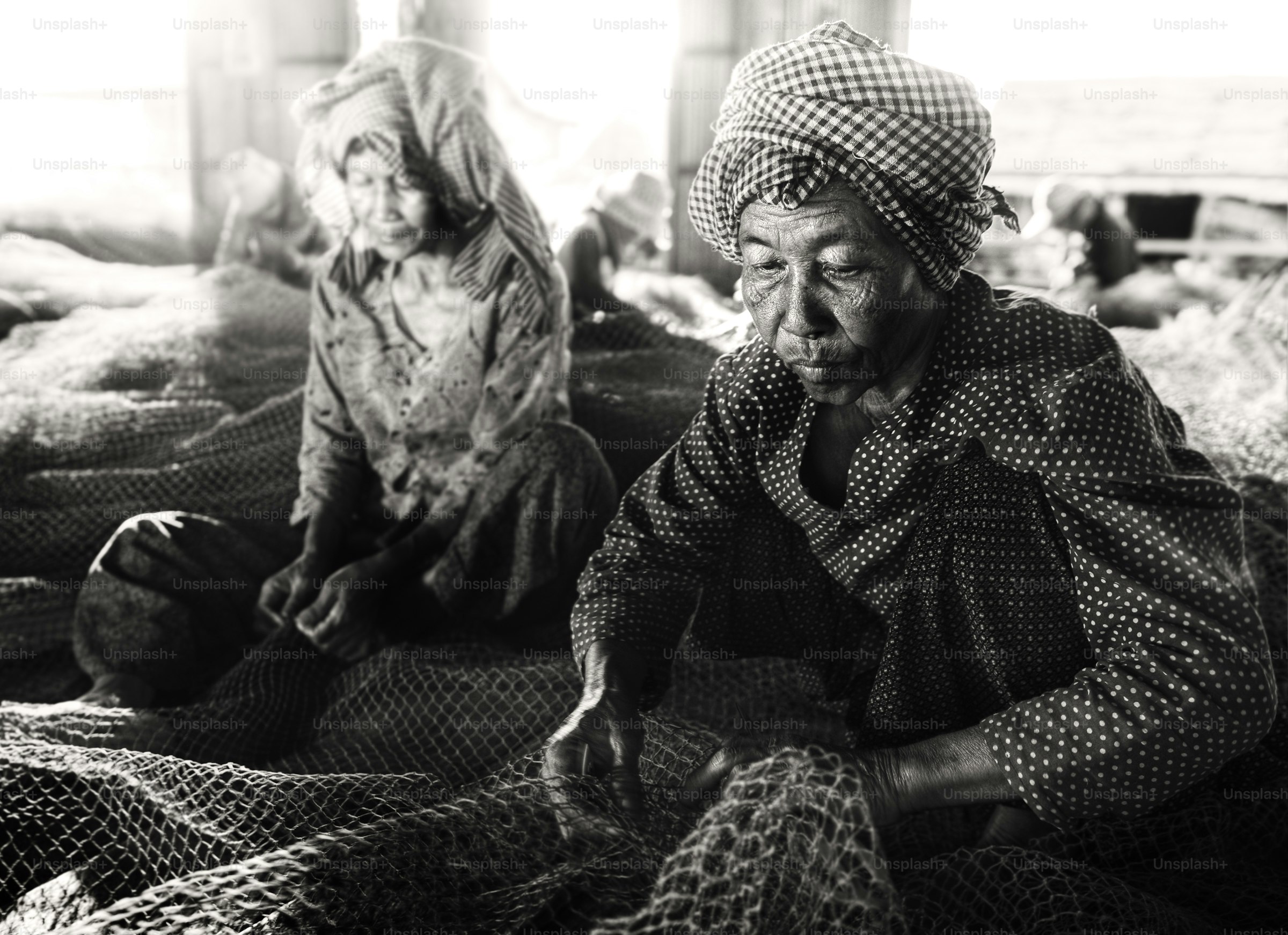 Two people working with fishing nets