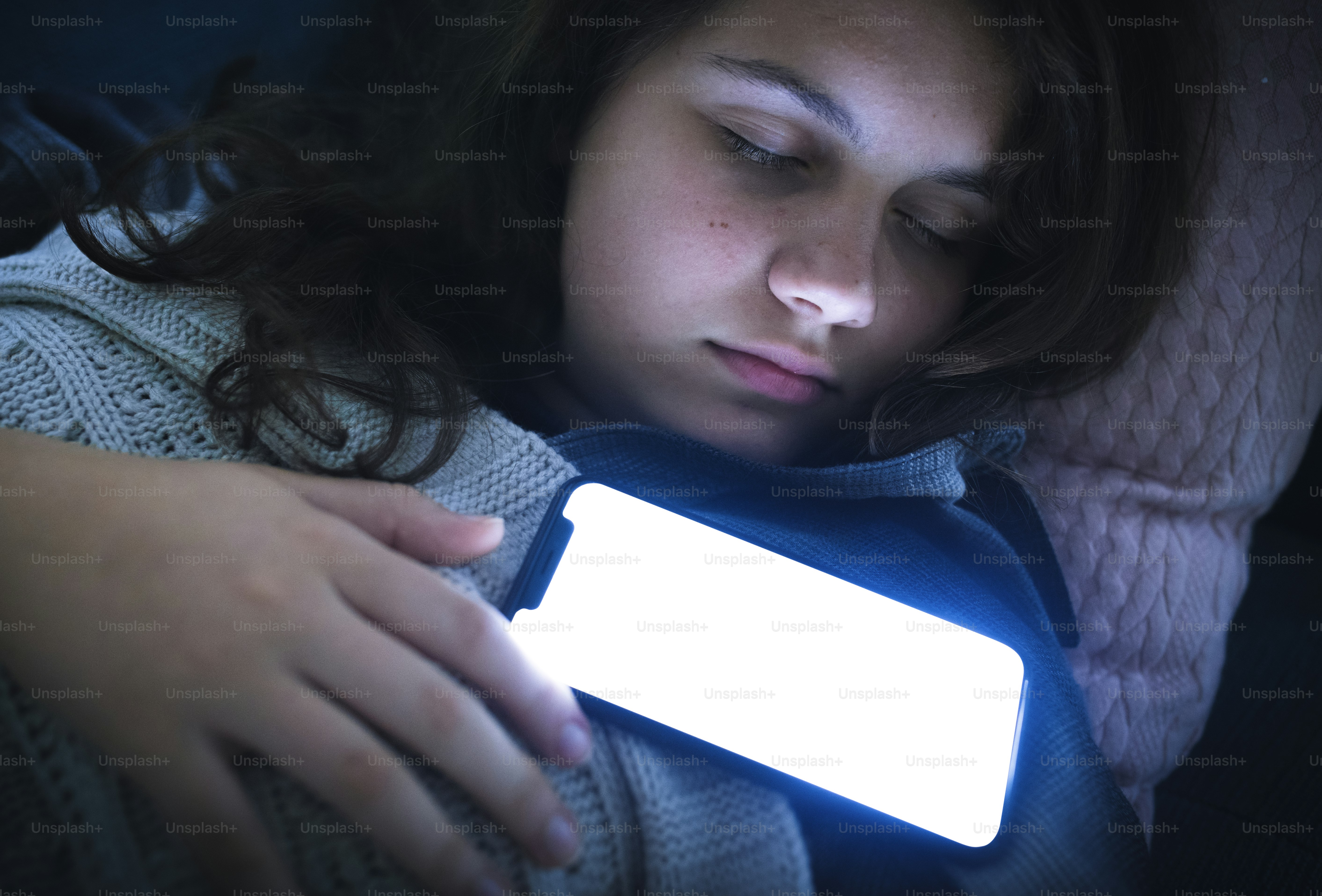 Girl fast asleep with her phone on her chest