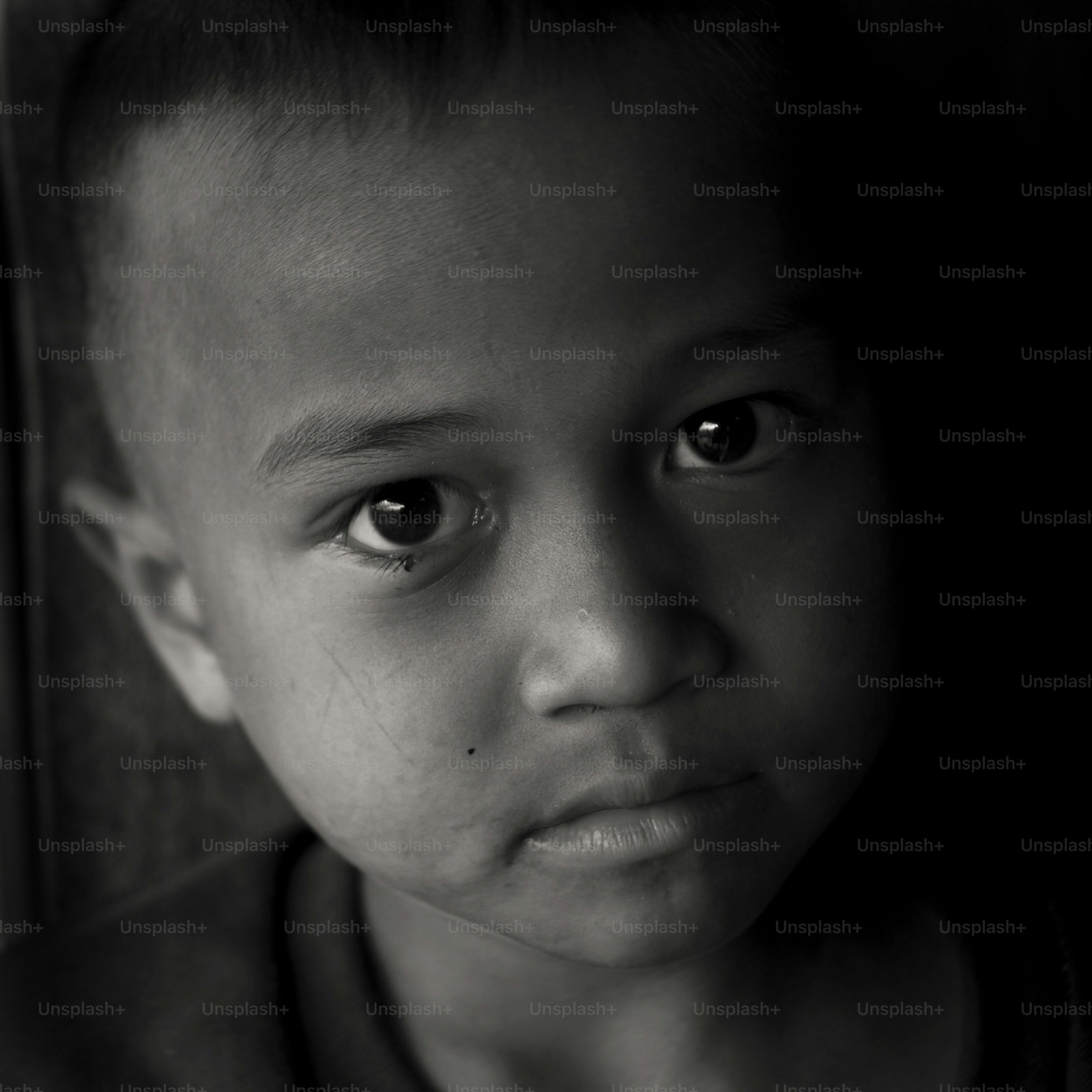 Close-up black and white portrait of a young boy.