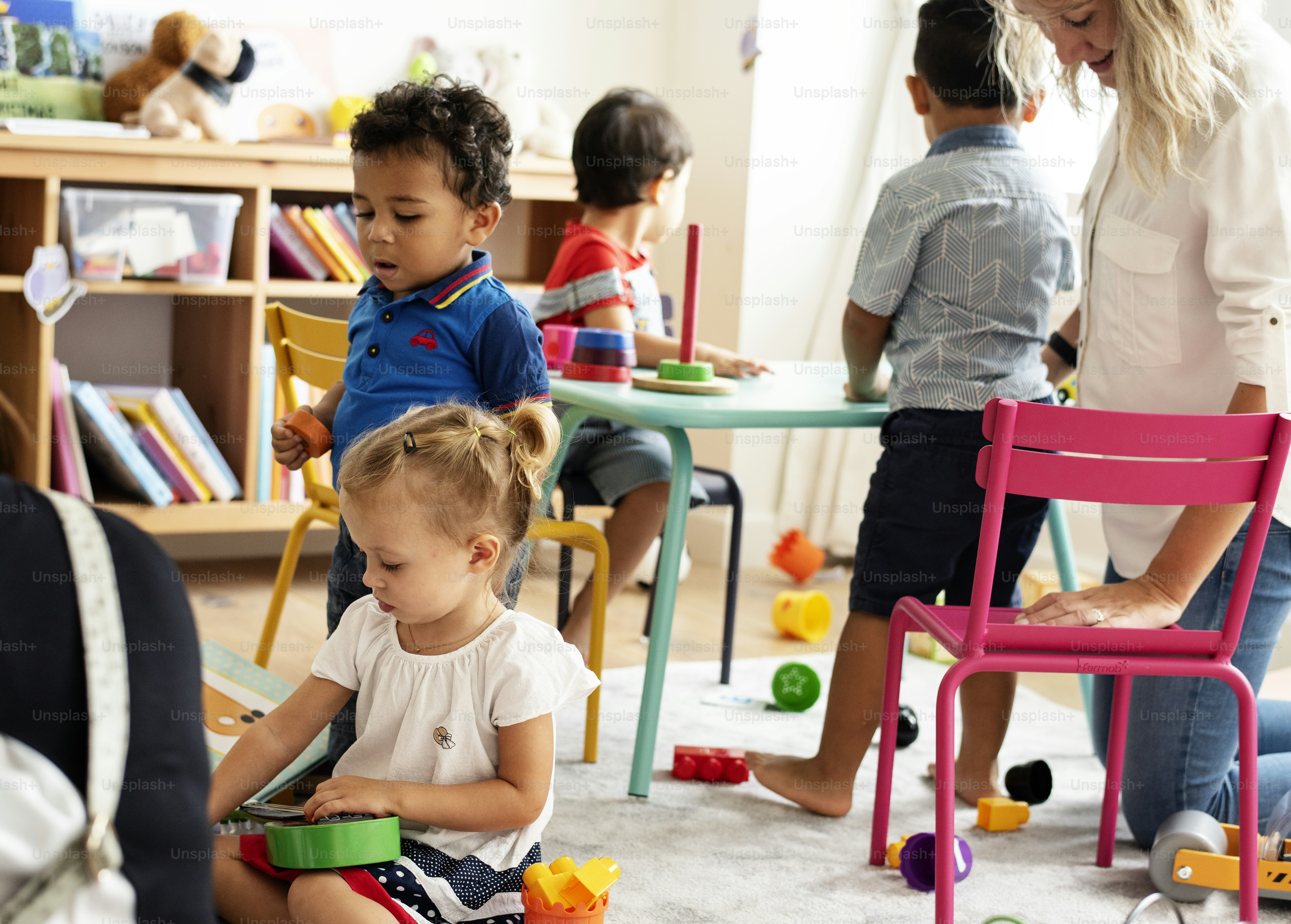 Nursery children playing and learning with a teacher