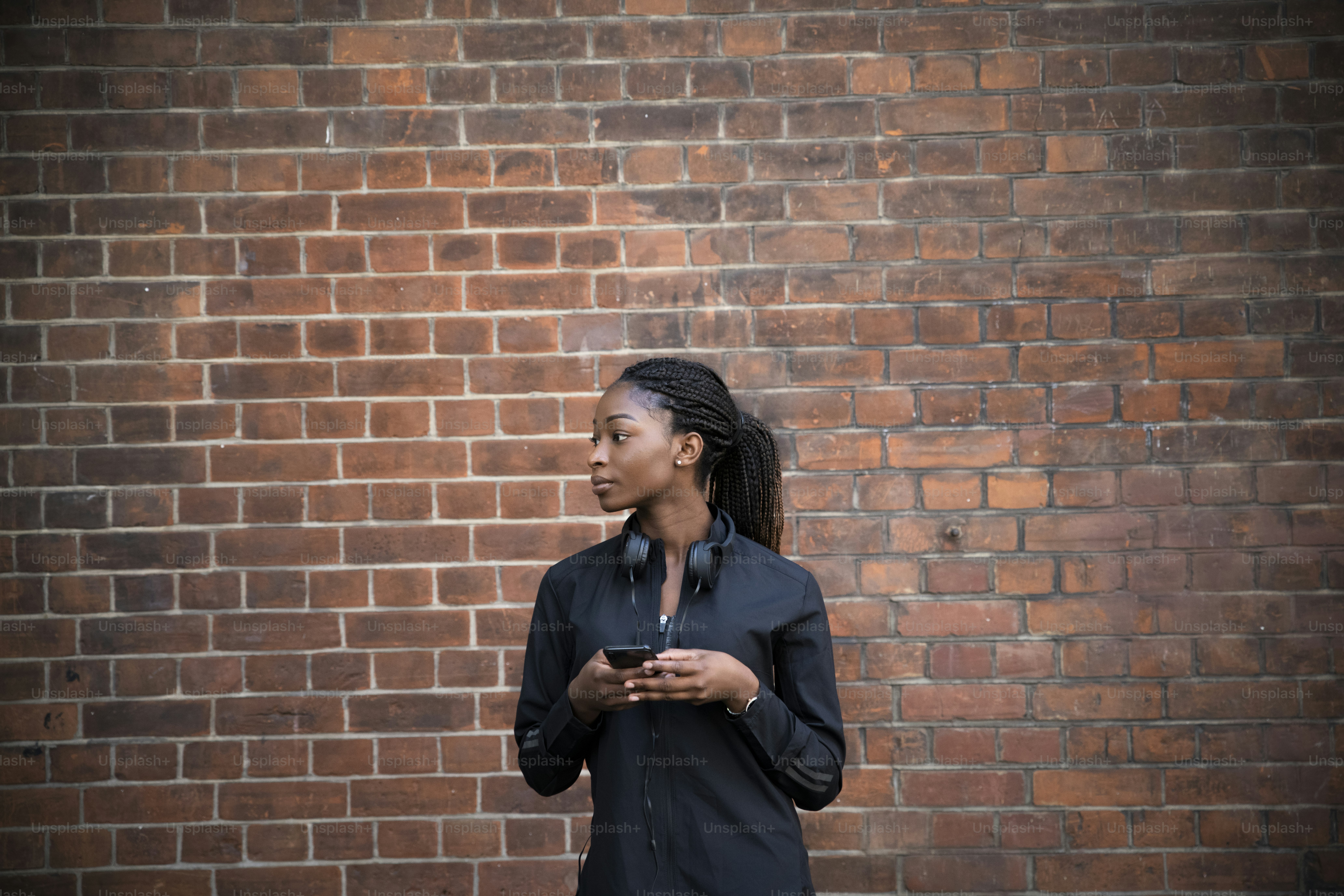 스포티한 여성이 휴대폰을 들고 있다