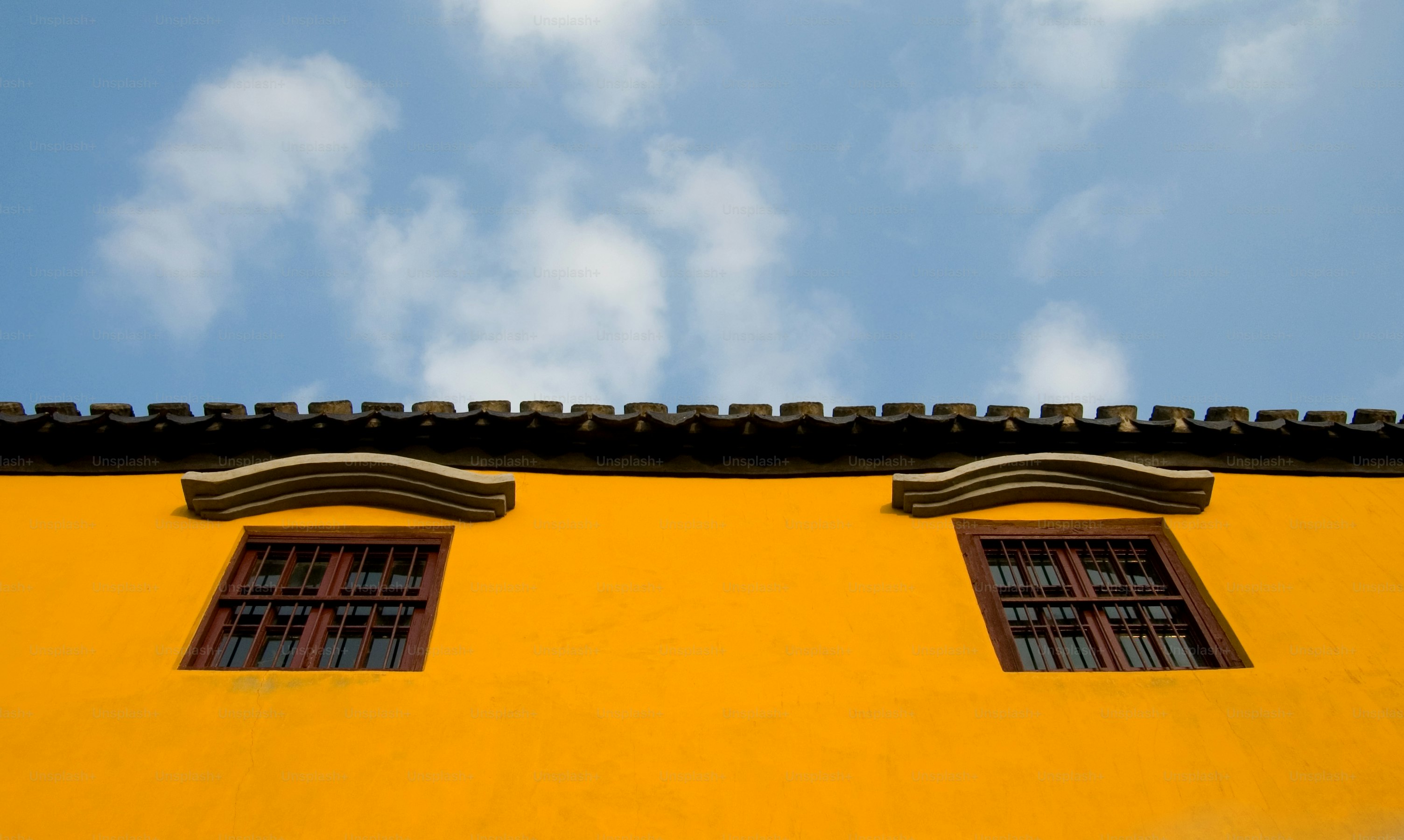 Vibrant yellow building in a Chinese temple complex.