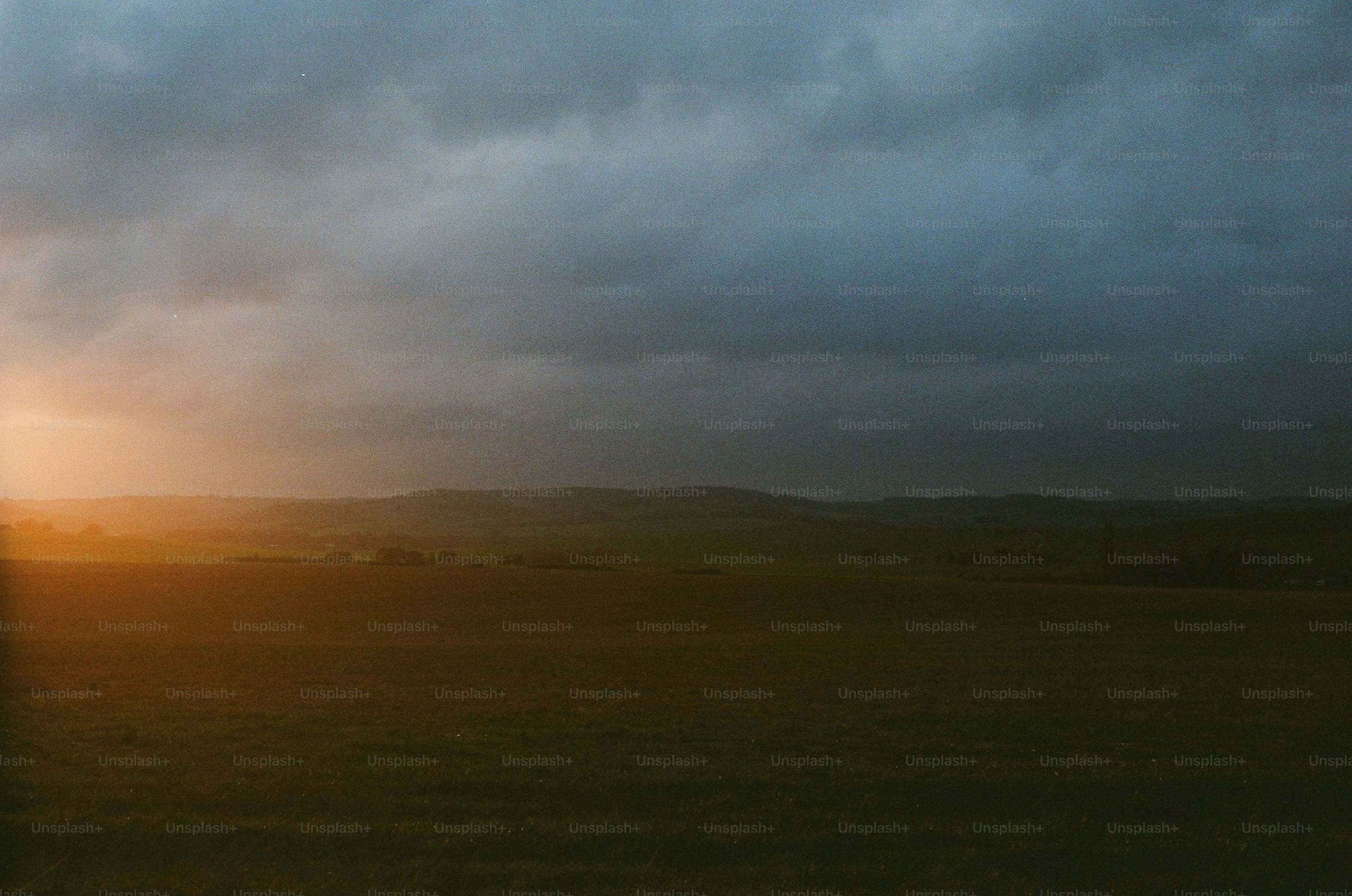 Dark stormy clouds over a rural landscape at sunset photo – Field Image ...