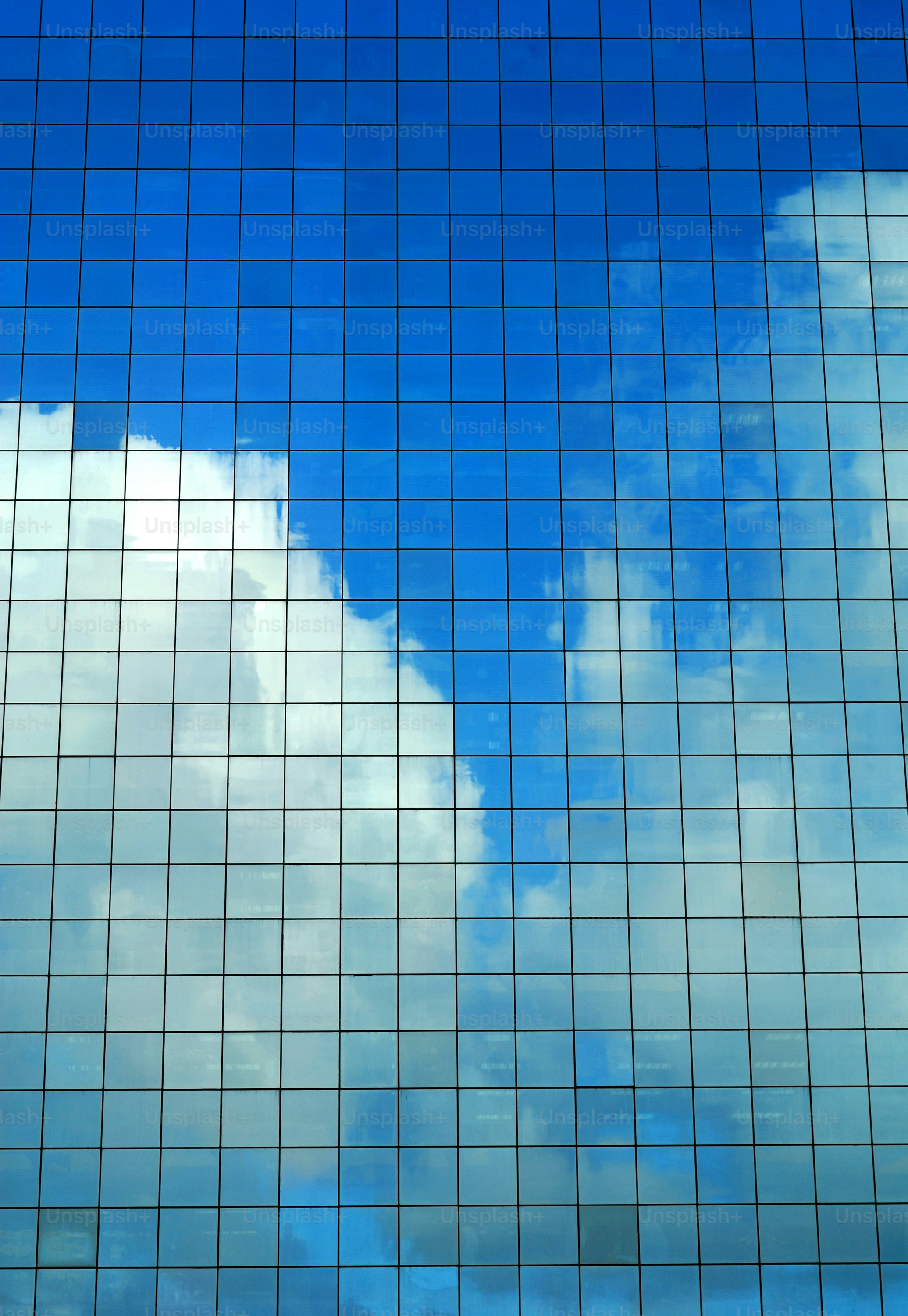 Sommerhimmel spiegelt sich in einem modernen Bürogebäude.