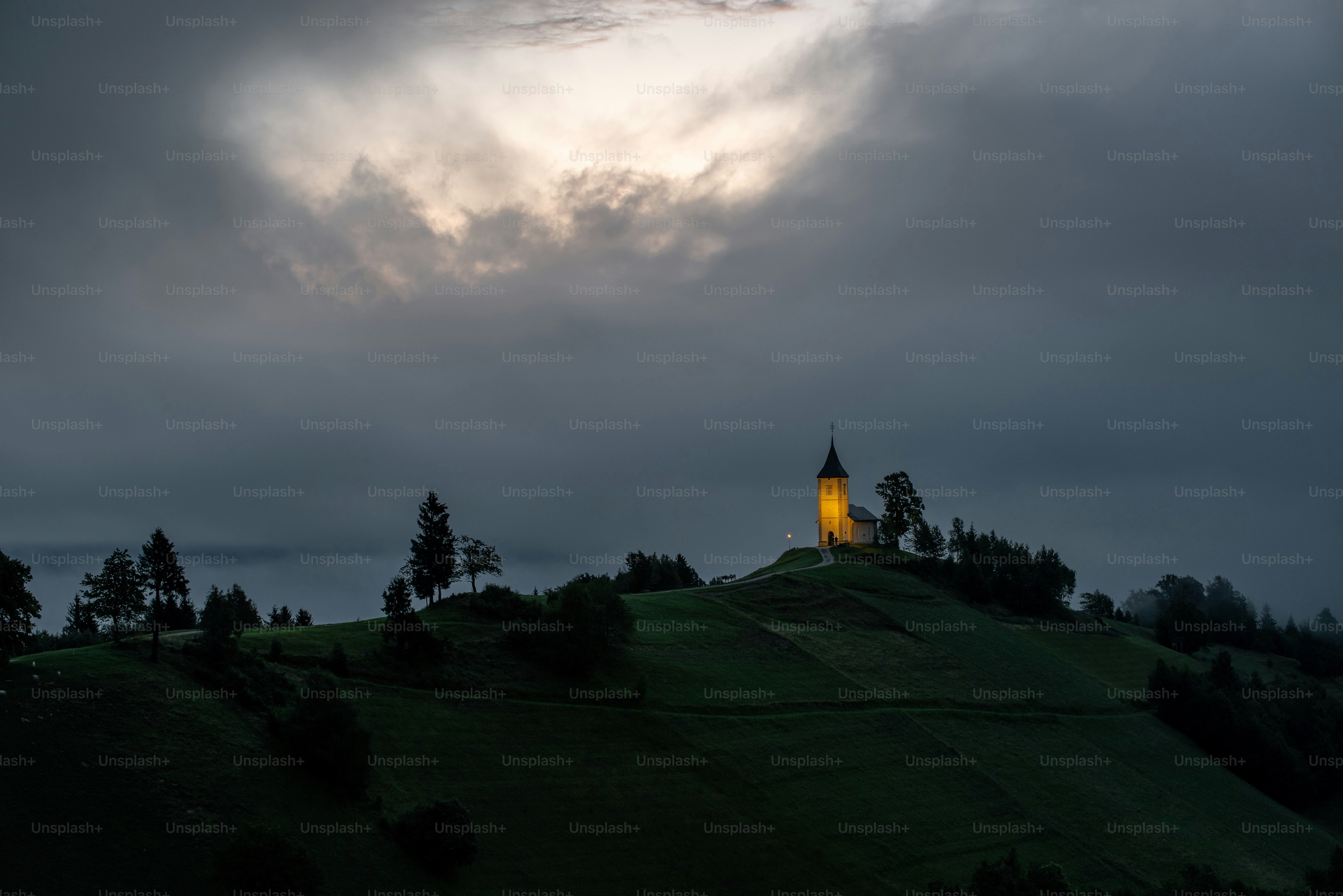 Église illuminée sur une colline au crépuscule