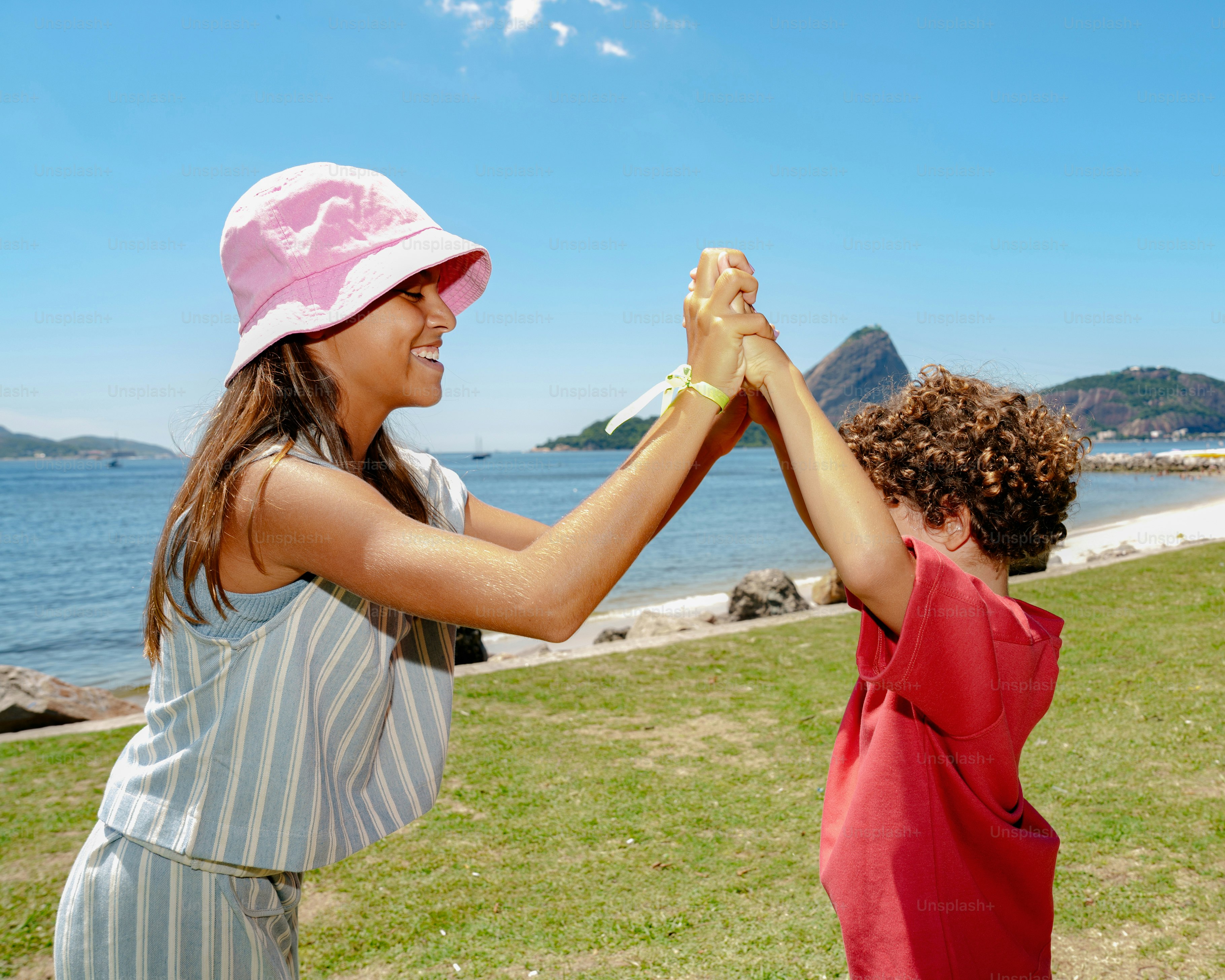 Woman and child high-fiving by the ocean