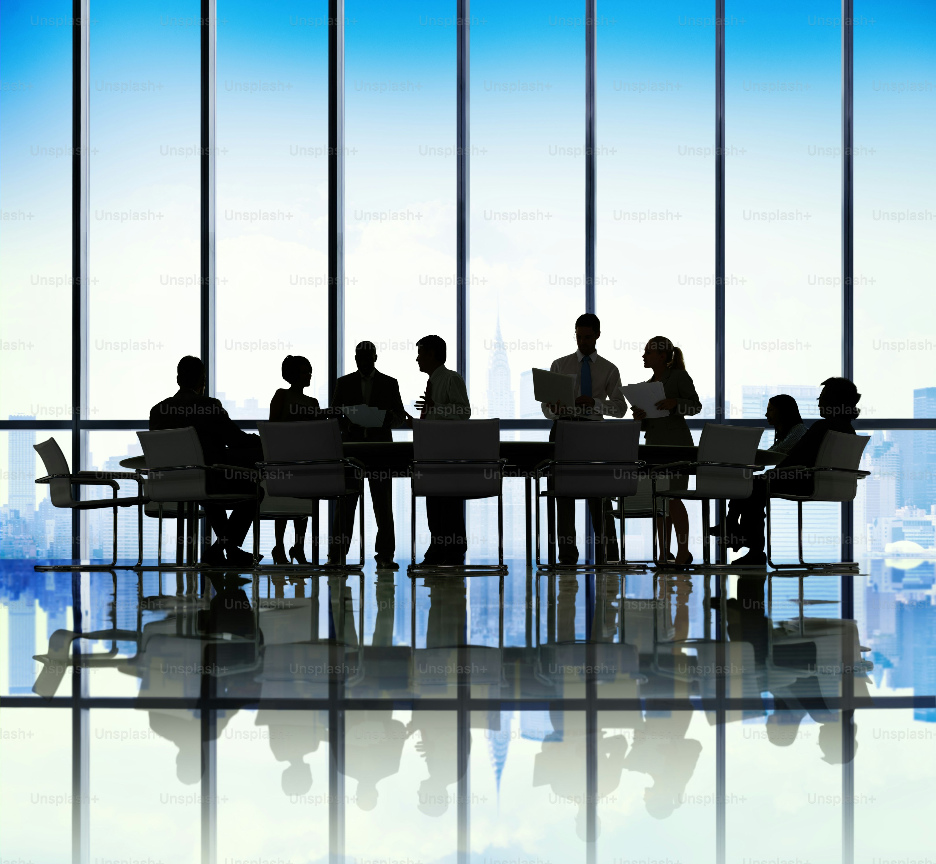 A team meeting in a boardroom at dusk