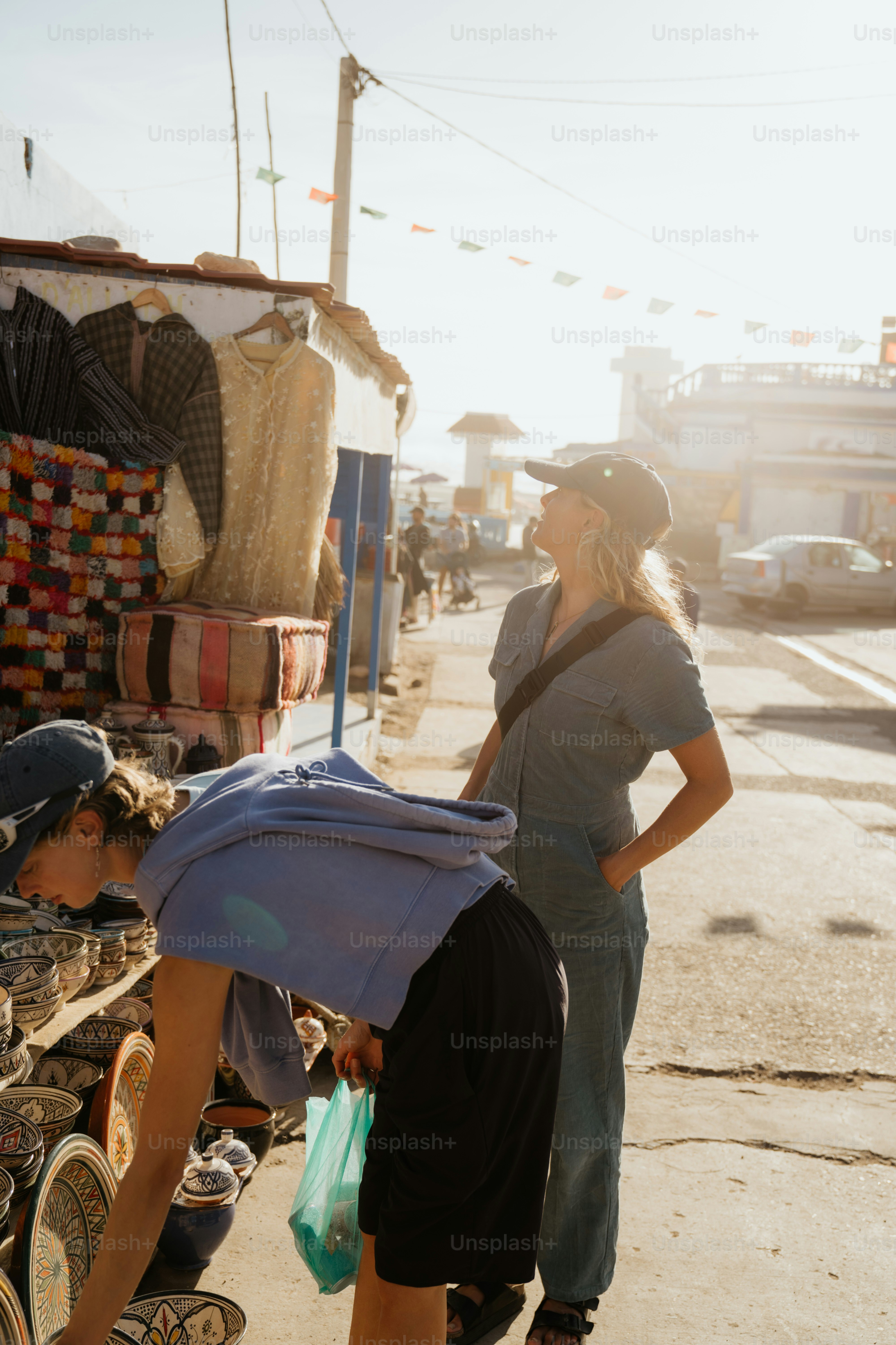 Two women browsing items at an outdoor market stall