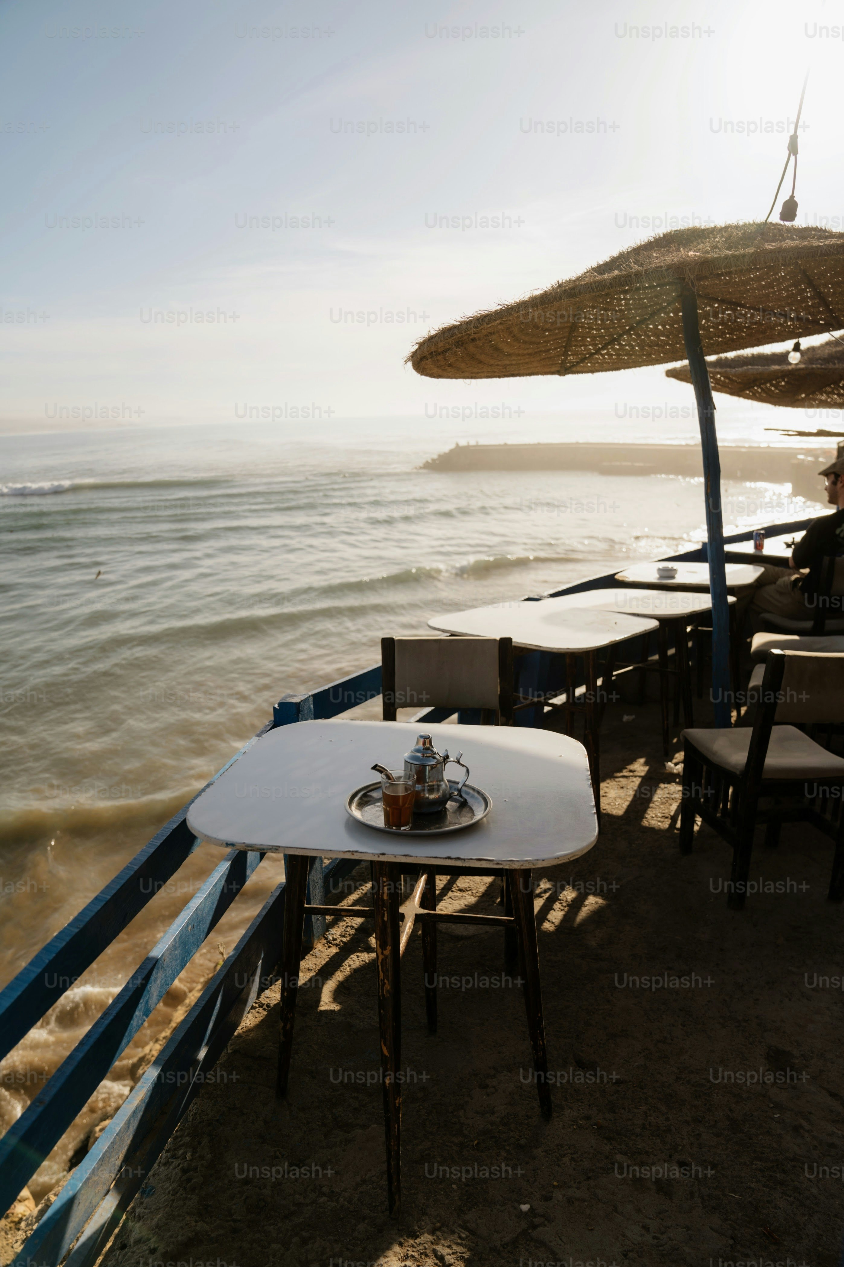 Outdoor cafe table with tea set by the ocean.