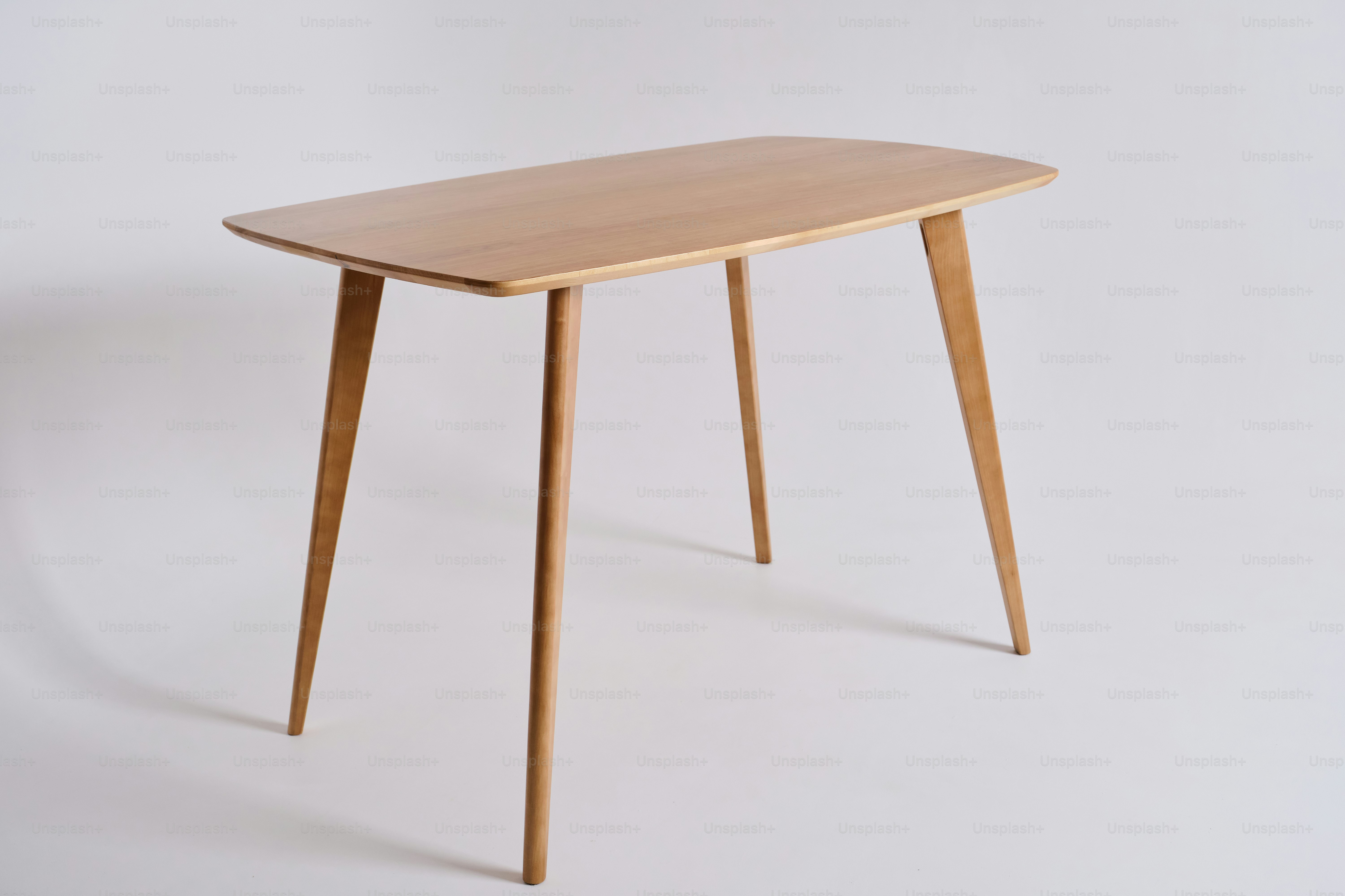 Una mesa sencilla de madera con cuatro patas cónicas