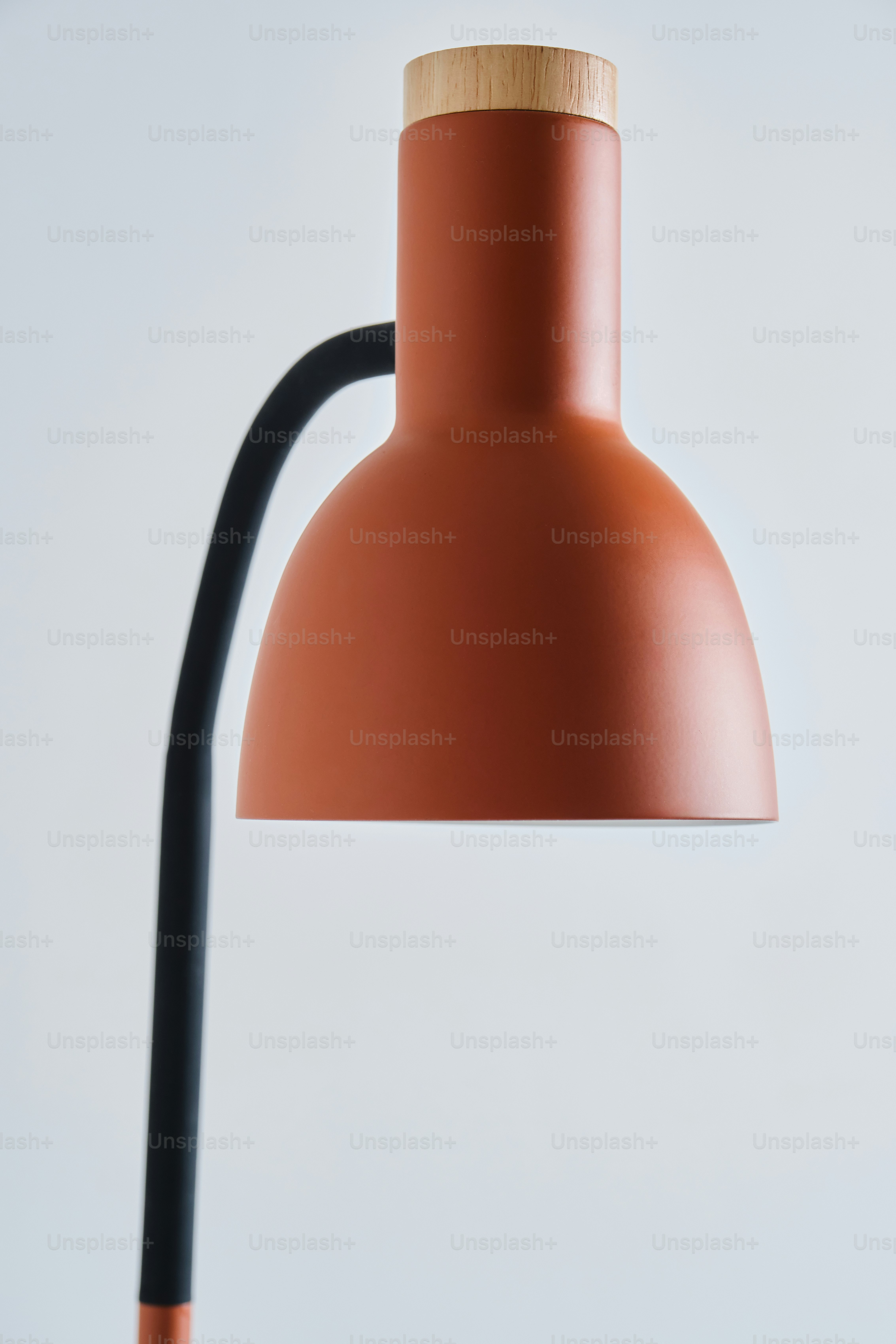 Una lámpara de escritorio moderna naranja con tapa de madera.