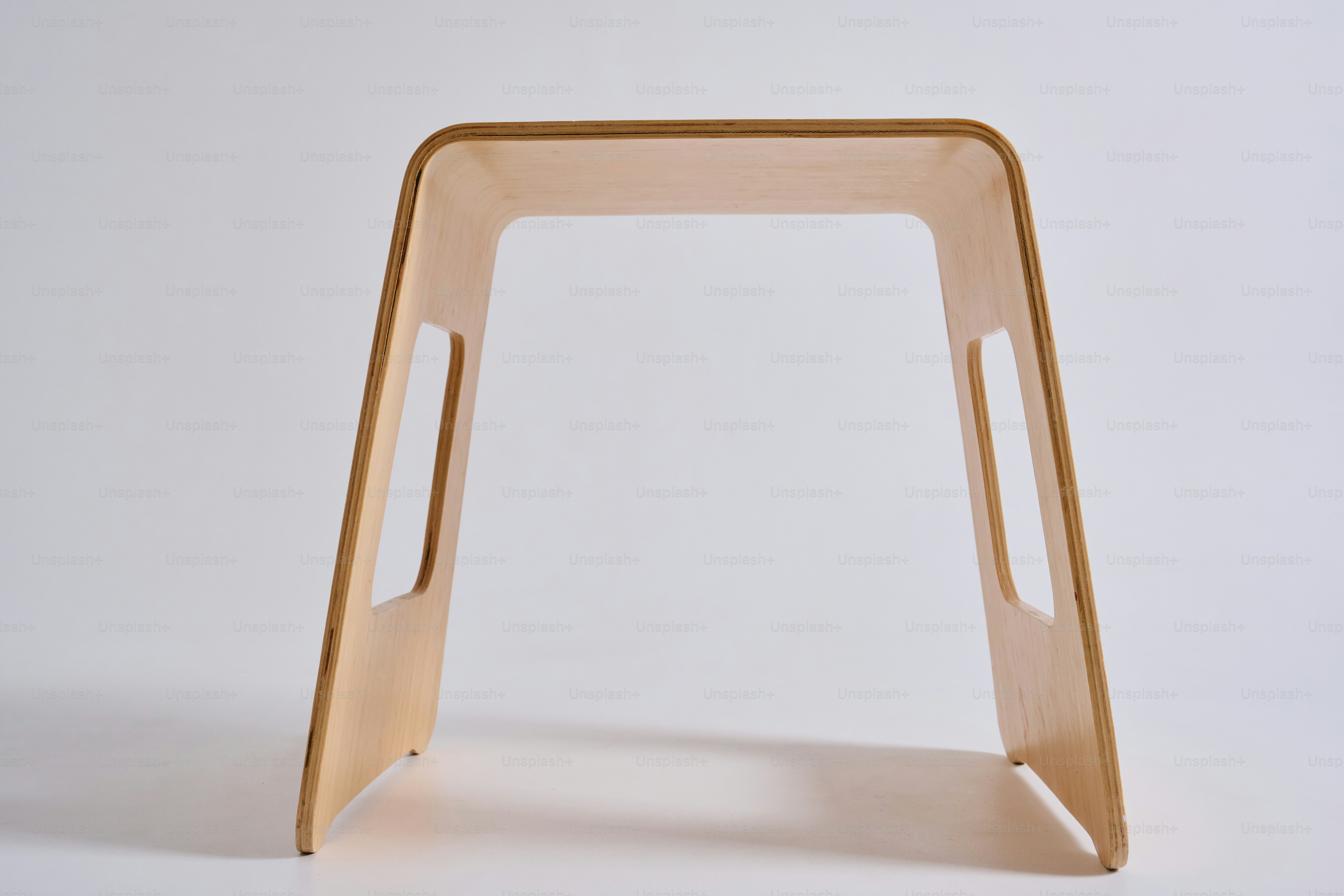 Un taburete minimalista de madera con asas recortadas