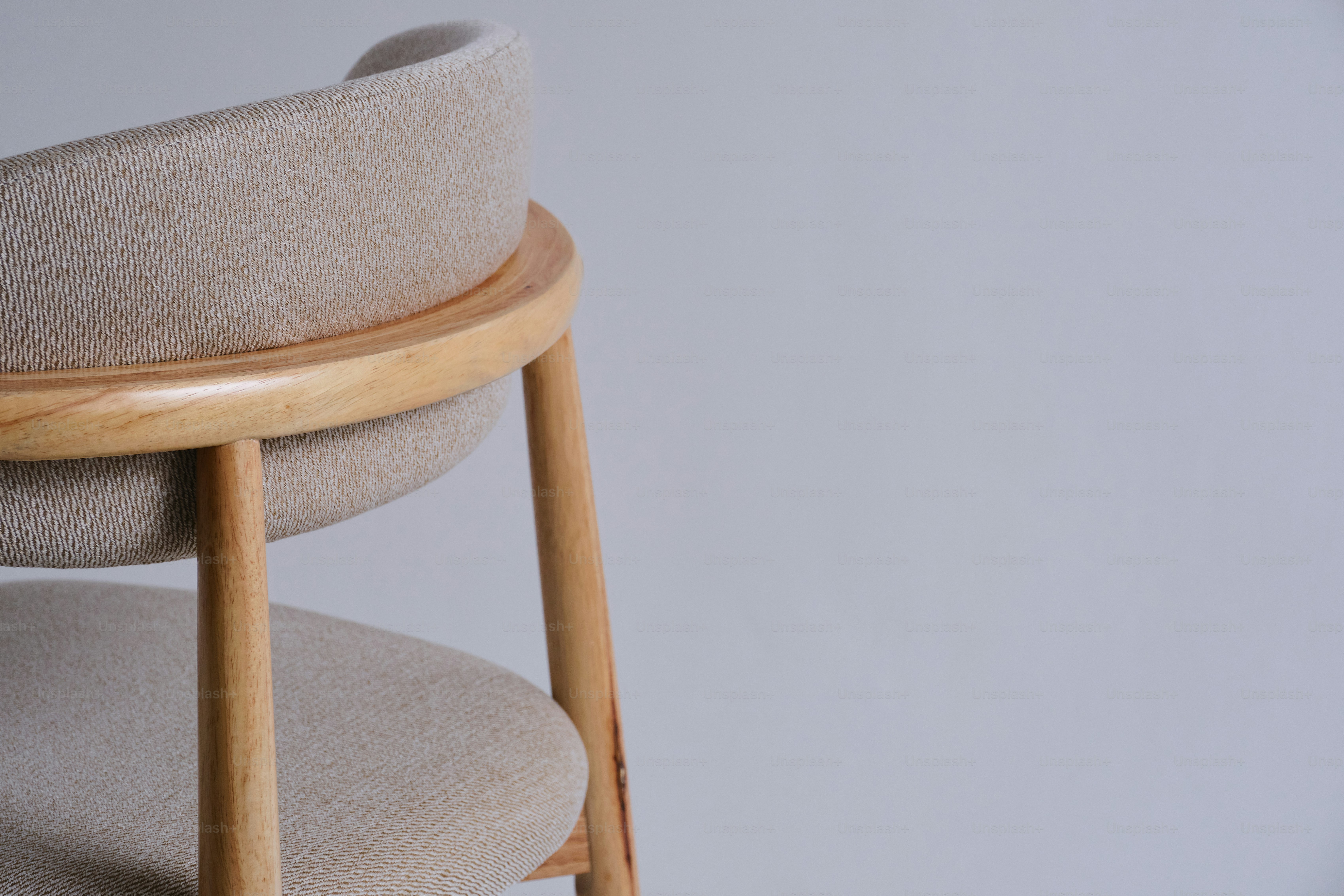 Una silla moderna con respaldo curvo y marco de madera.