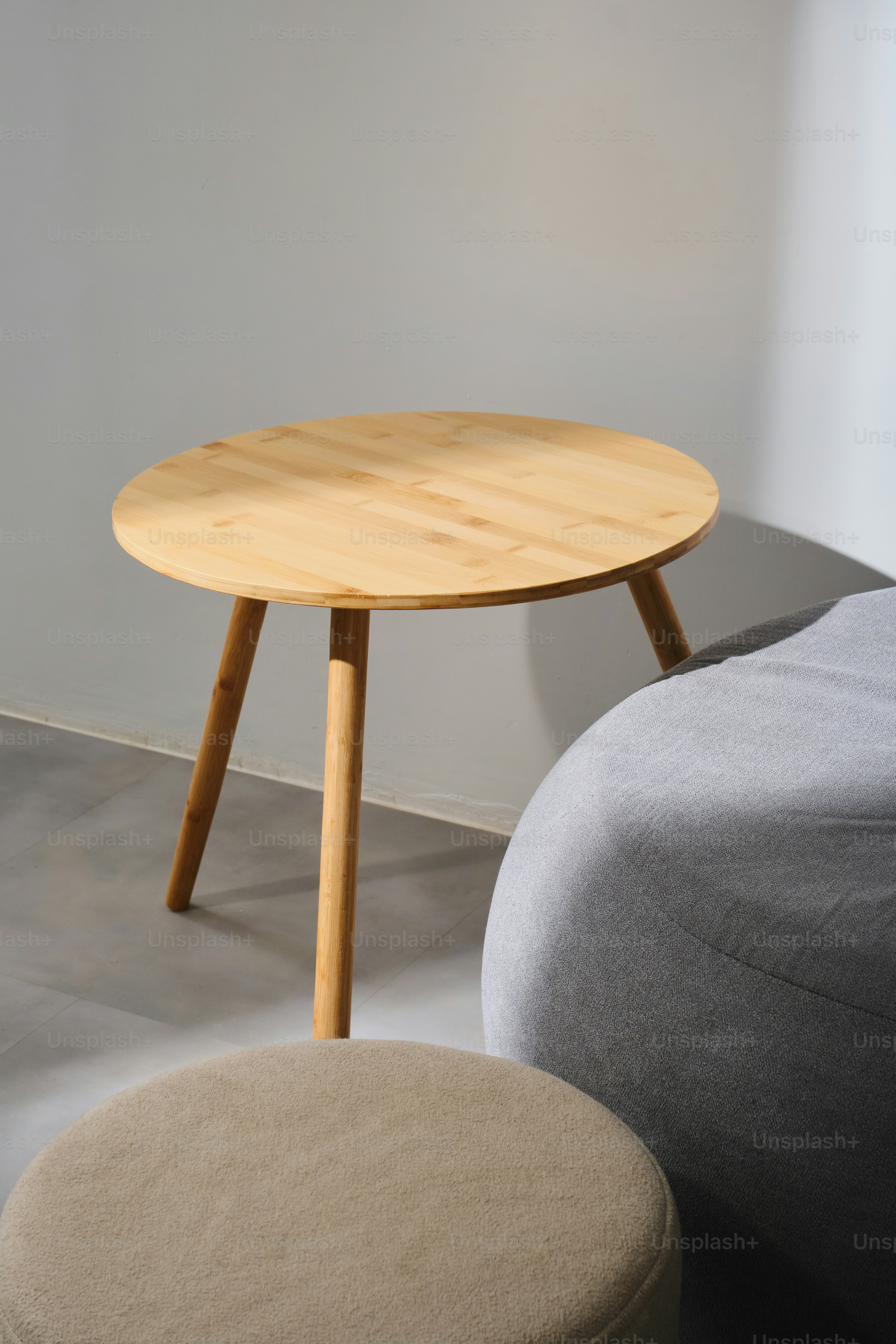 Una mesa redonda de madera con tres patas.