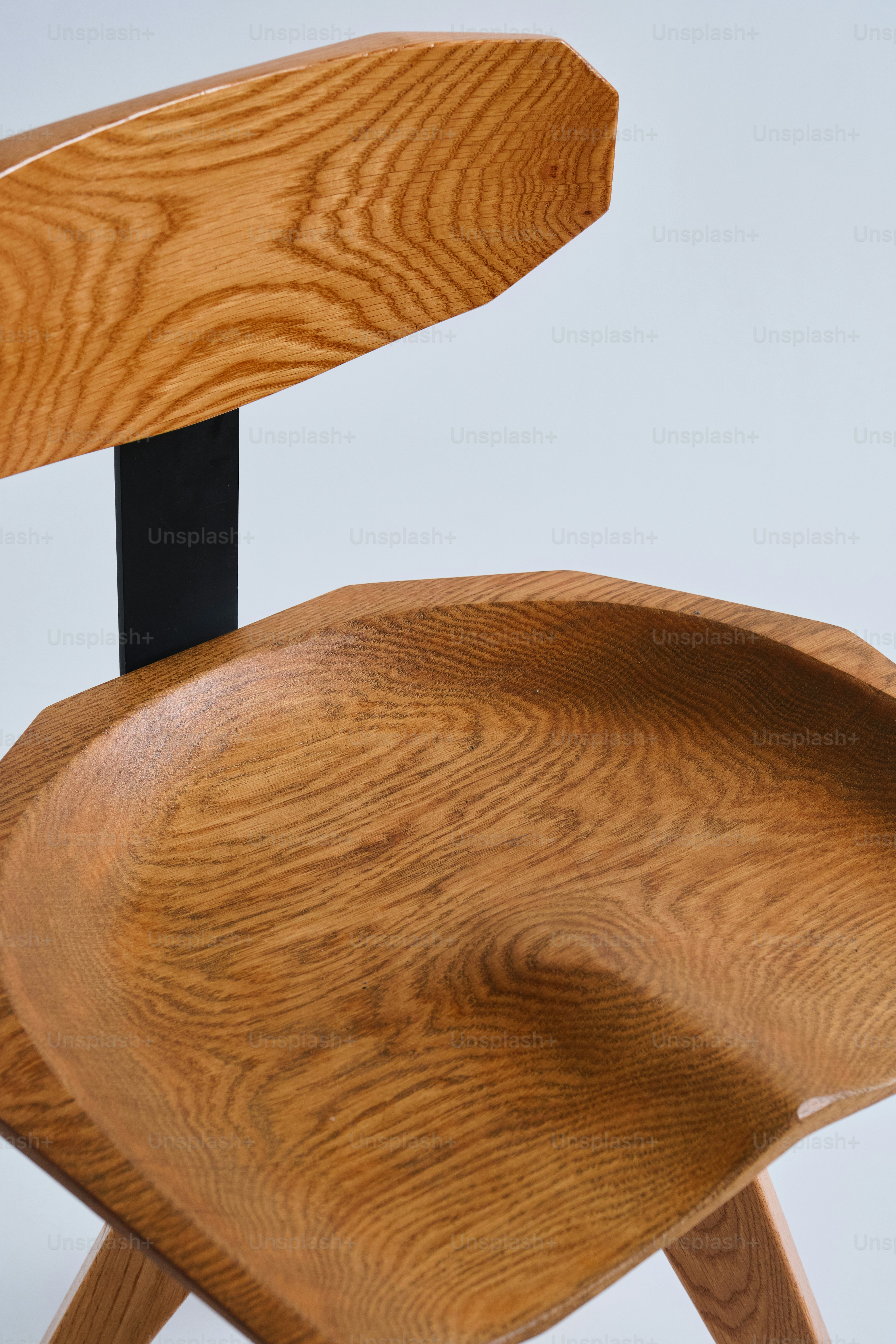 Primer plano de una silla de madera tallada con detalles en metal negro