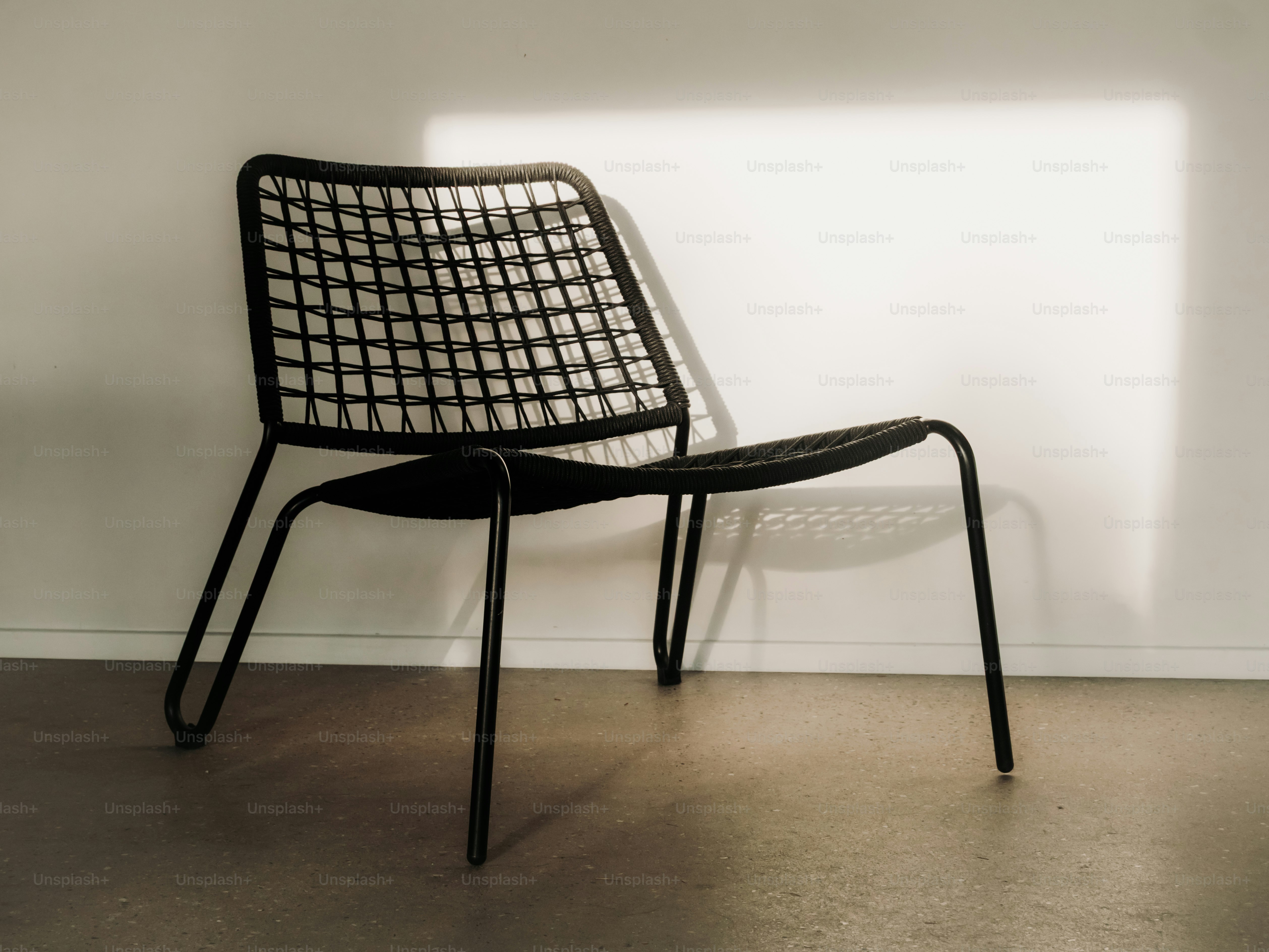 A black modern chair casts a shadow on the wall. photo – Interior ...