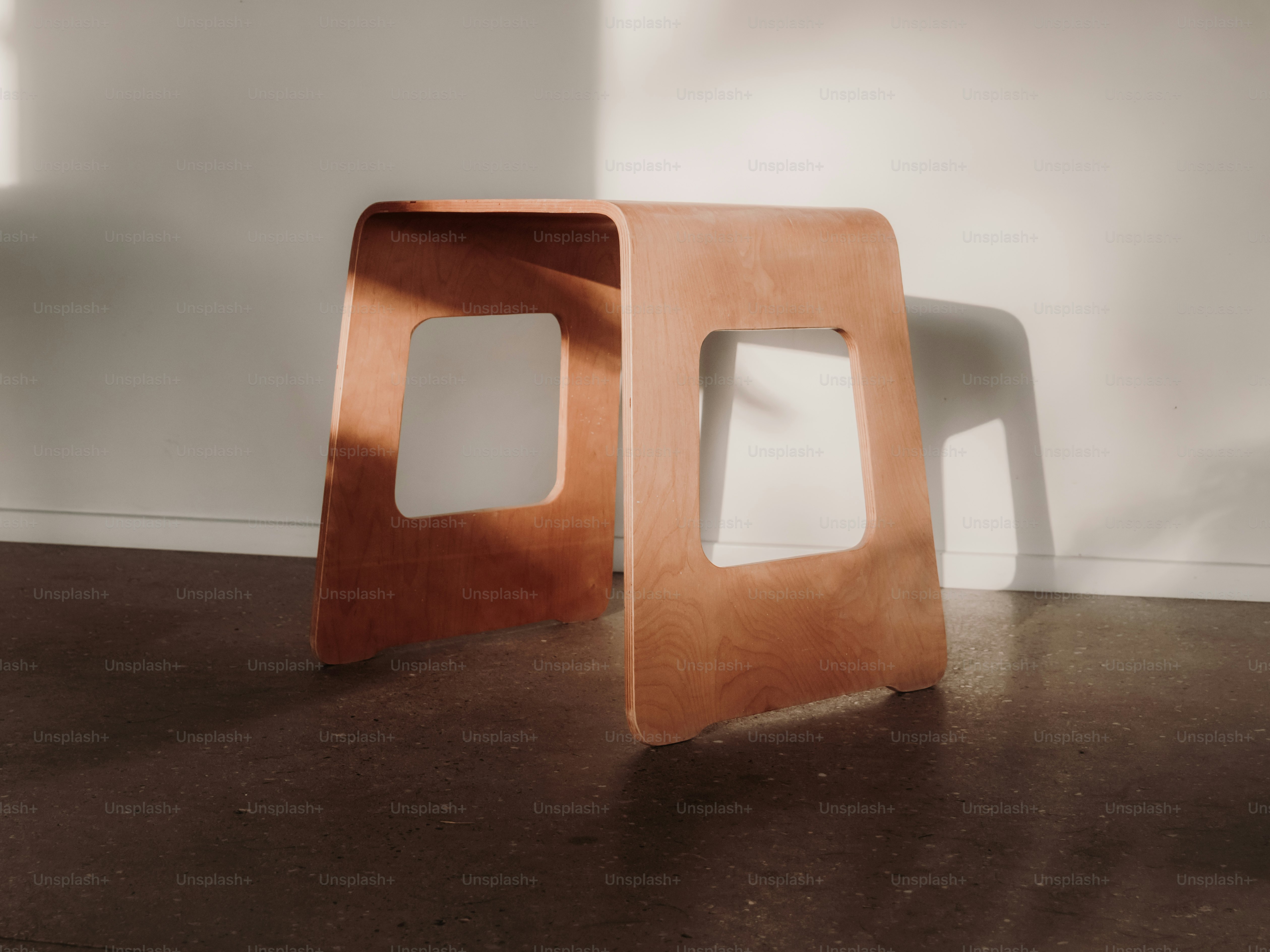 幾何学的な切り抜きが施された現代の木製スツール