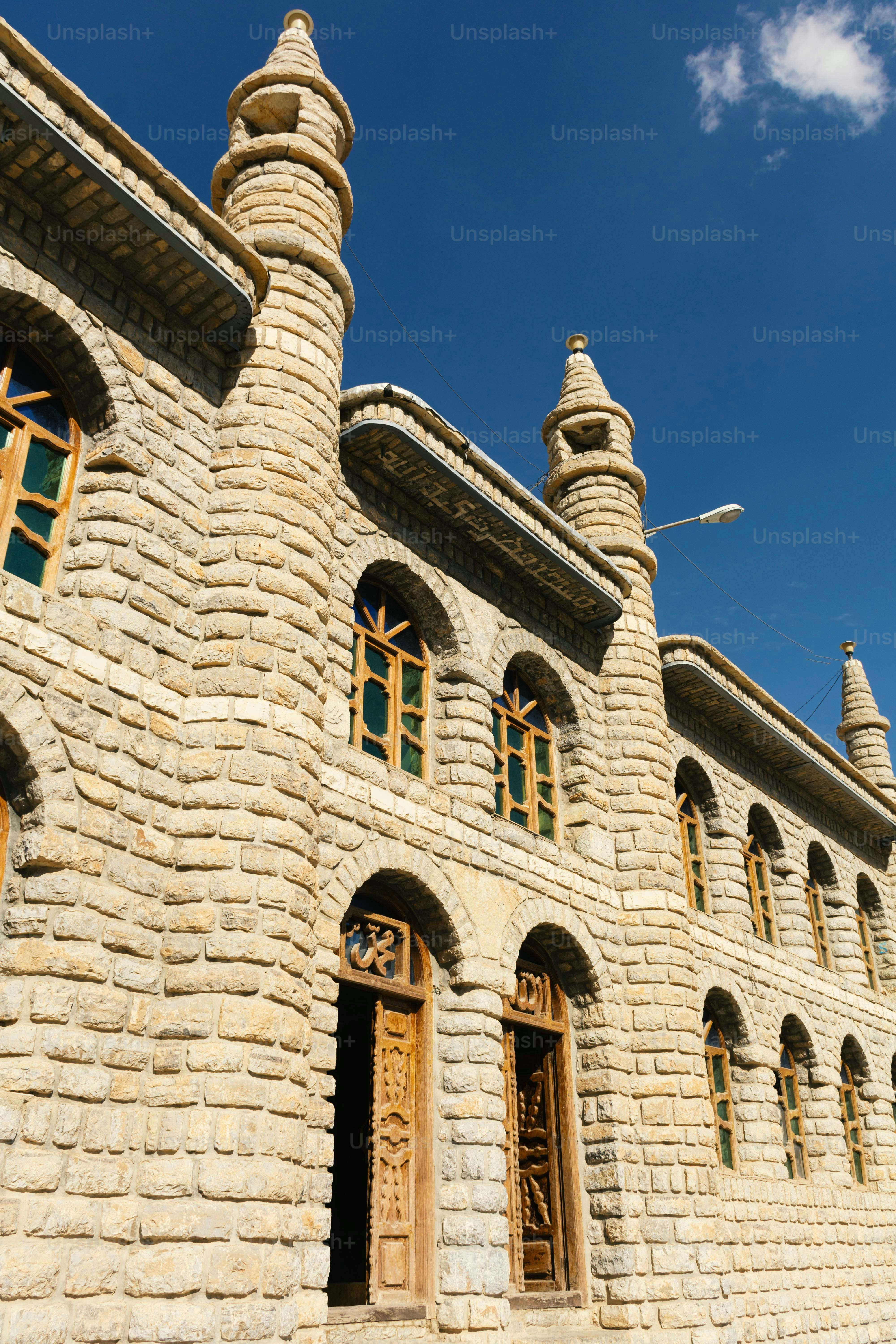 Edificio de piedra con ventanas arqueadas contra el cielo azul